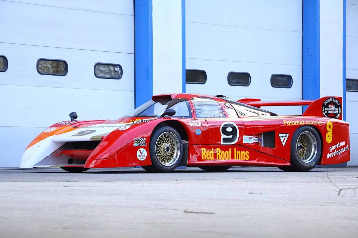Race car with red and white livery, side view.