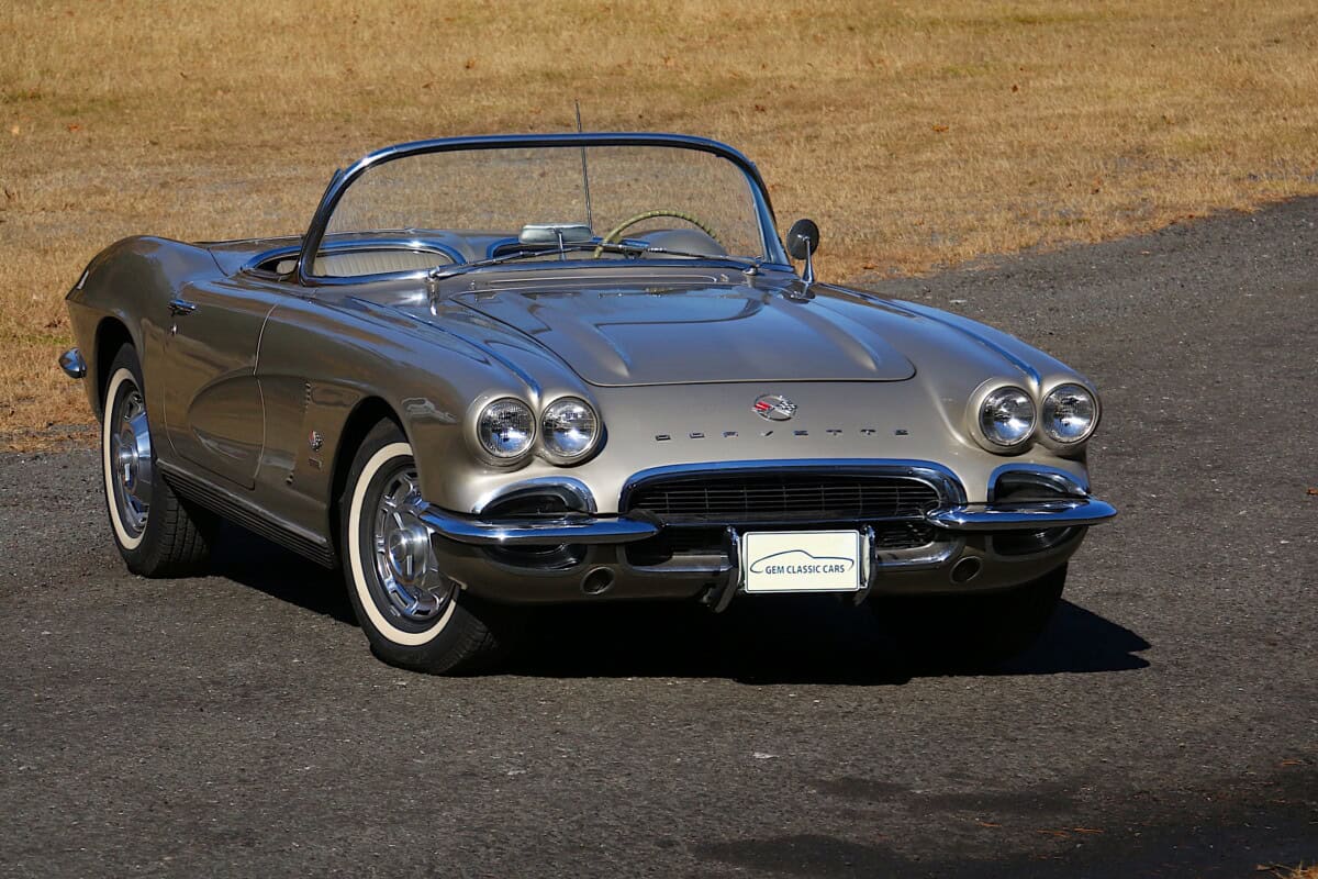 Classic car with convertible top, silver color, front view.