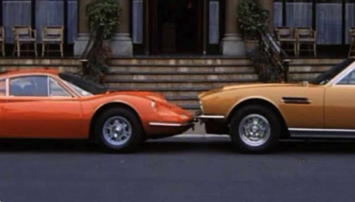 Exterior shot of two vintage cars parked in front of a building.