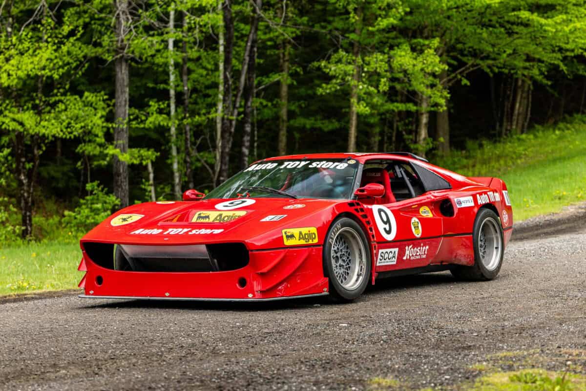 Exterior shot of classic red racing car with sponsor decals.