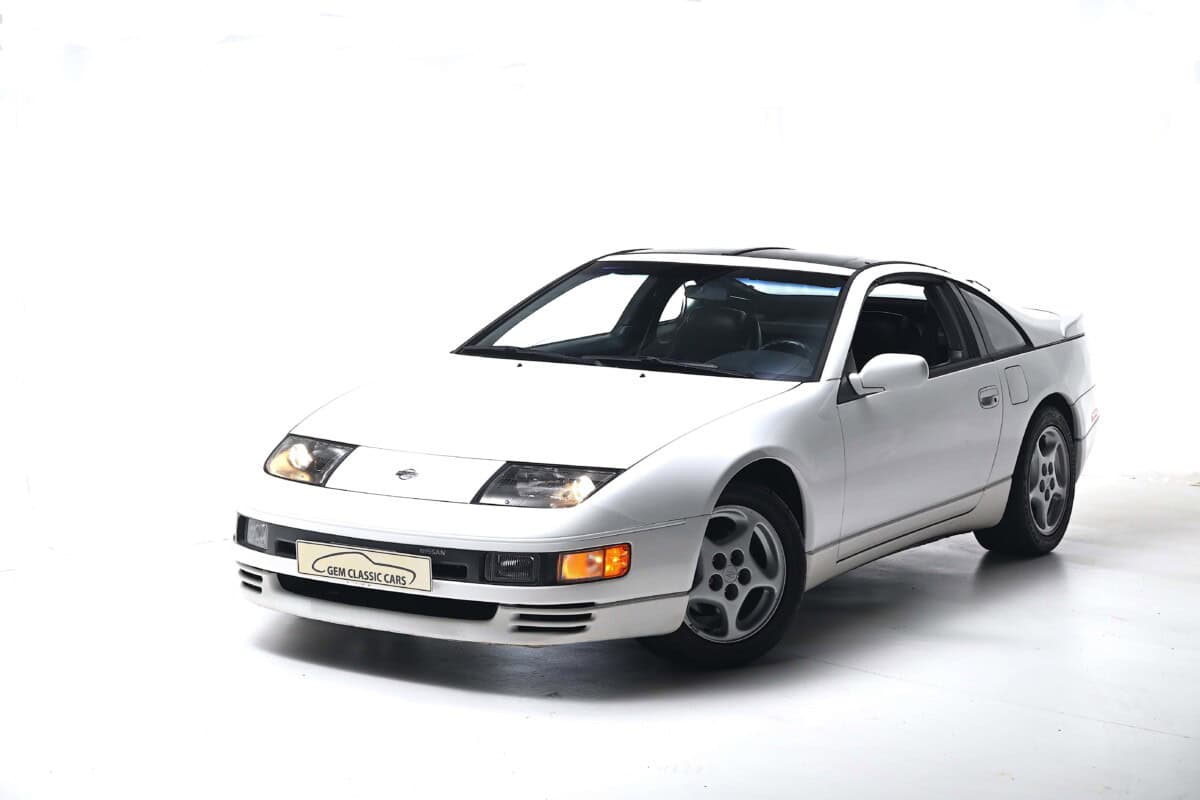 White classic sports car with sleek design, front view.