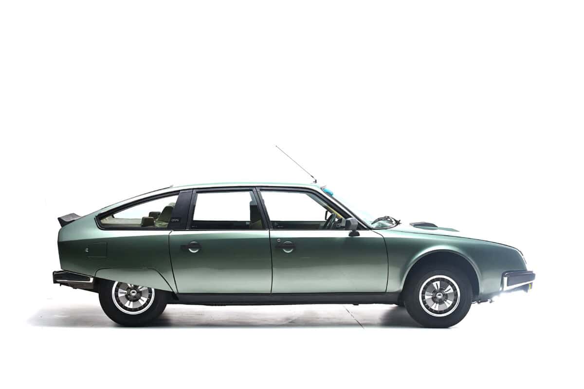 Exterior shot of a vintage green classic car, side profile.
