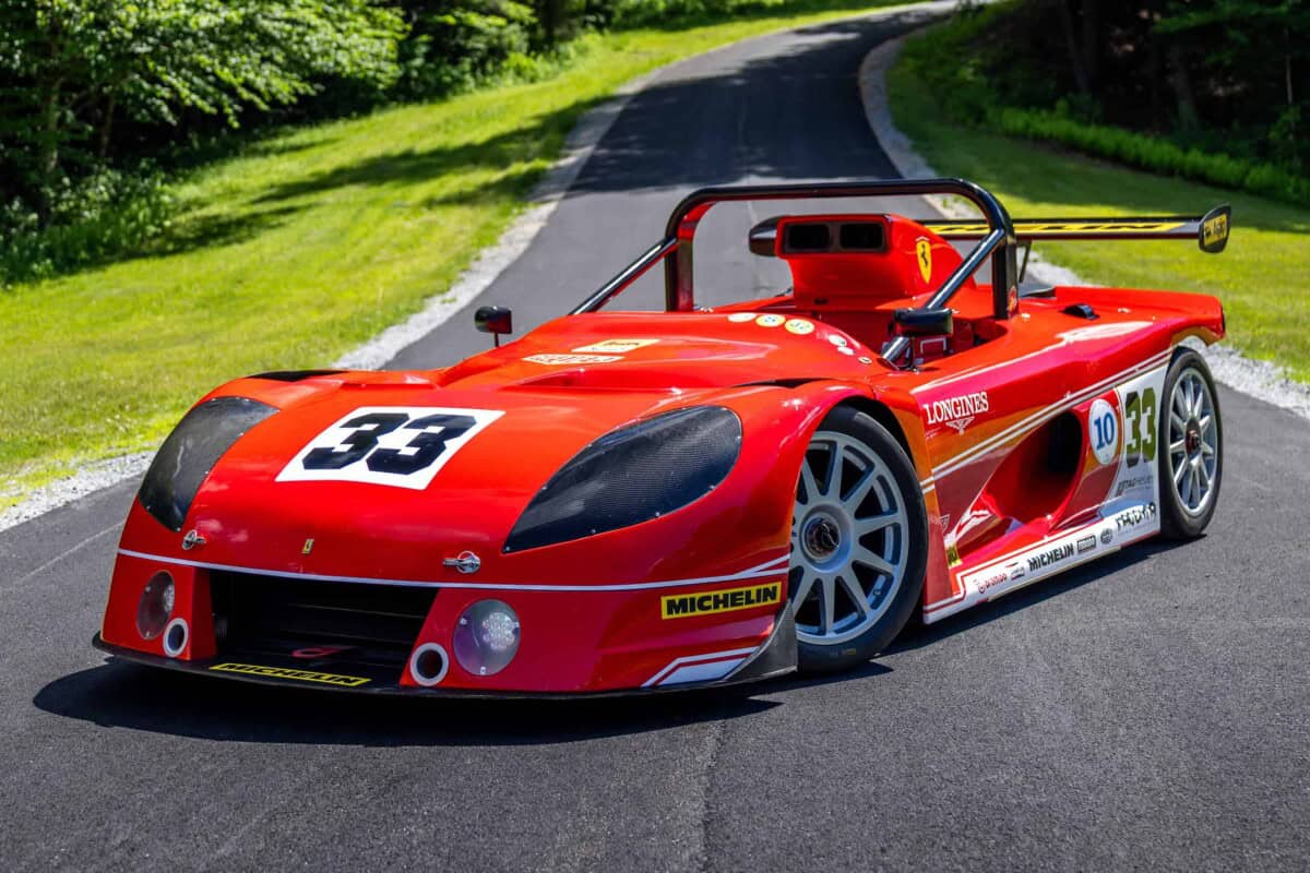 2000 Nogaro MR400 — Red classic race car with racing decals on asphalt road.