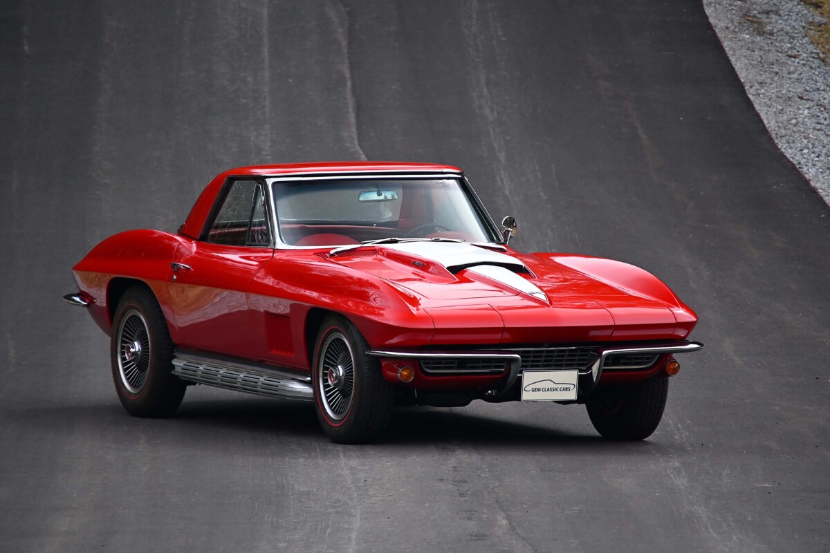 1967 Chevrolet CORVETTE — Exterior view of a shiny red Chevrolet Corvette sports car on the road.