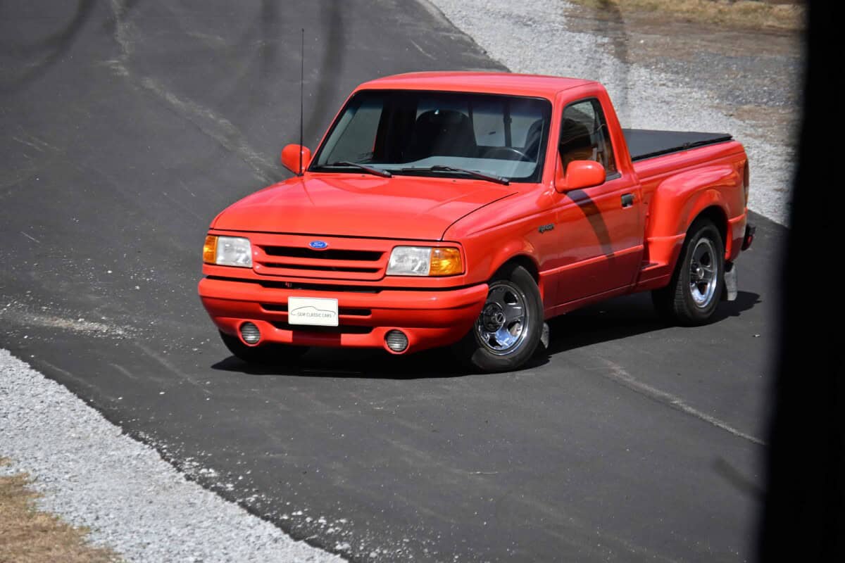 Exterior shot of a classic red pickup truck parked on the street.