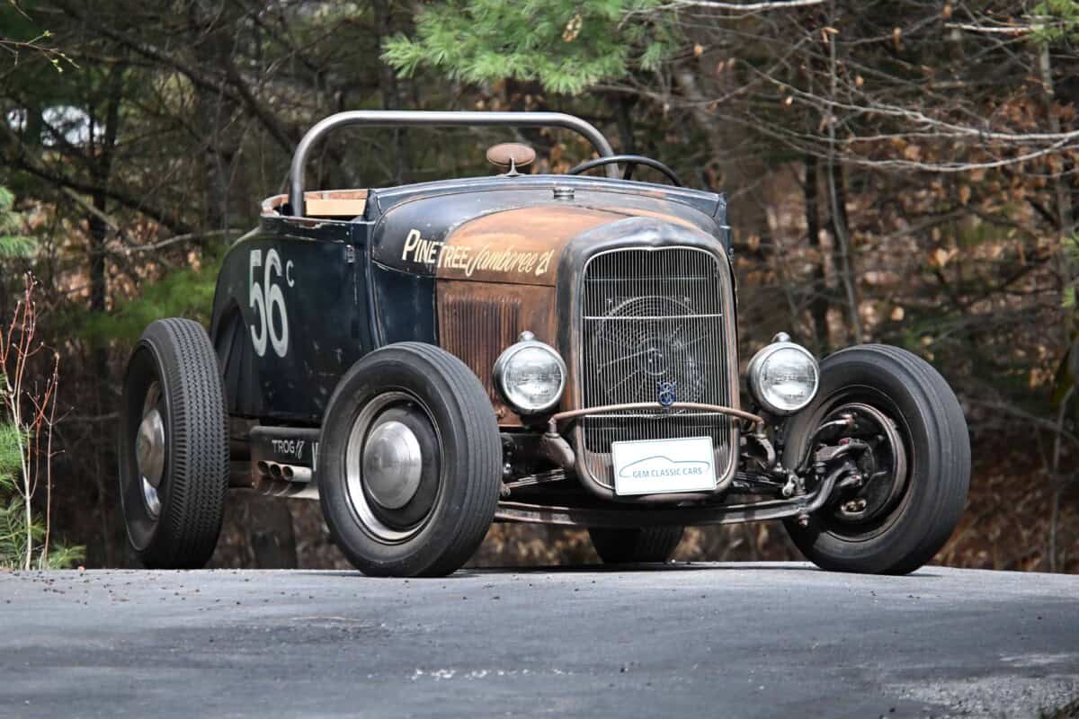 Vintage race car with weathered body and racing number 56, exterior shot.