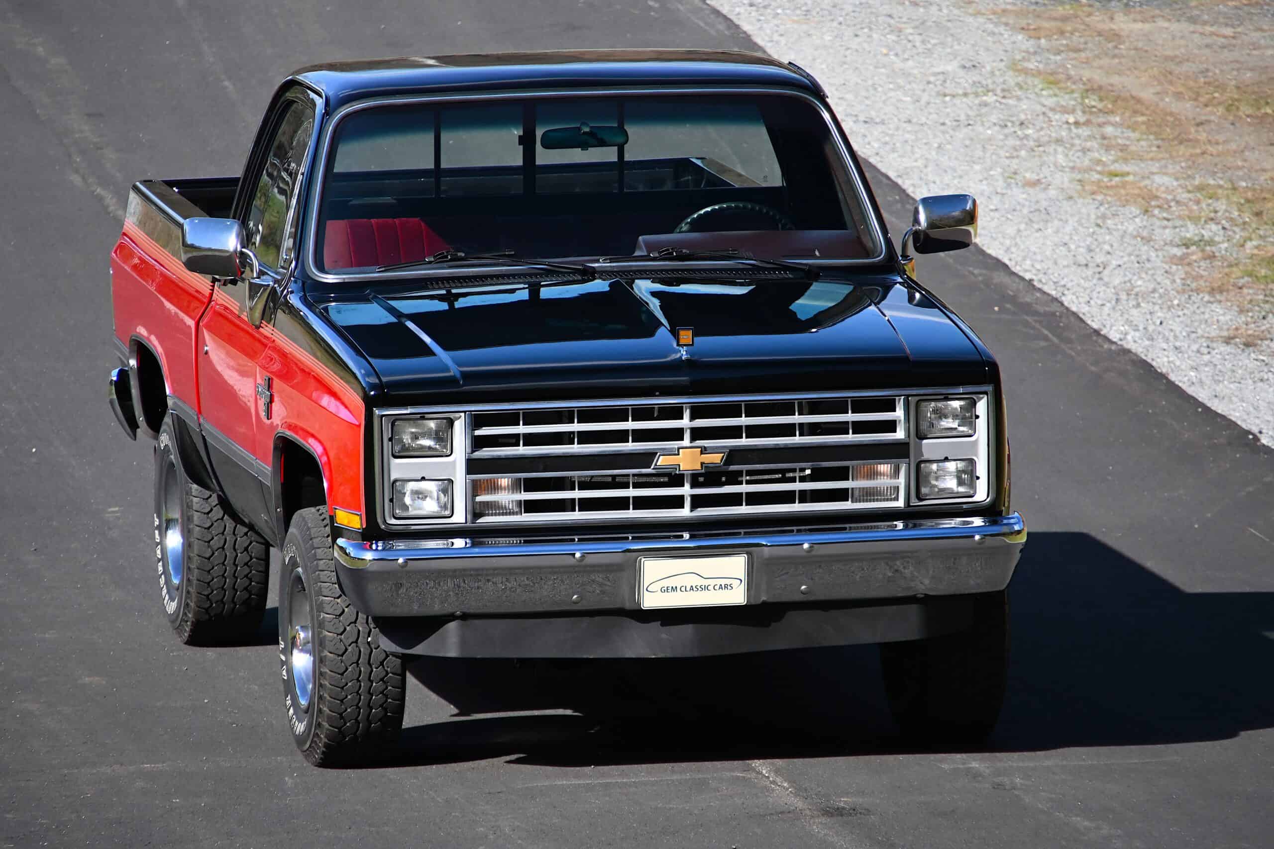 1986 Chevrolet SILVERADO — Classic car pickup truck with black and red body, front view.