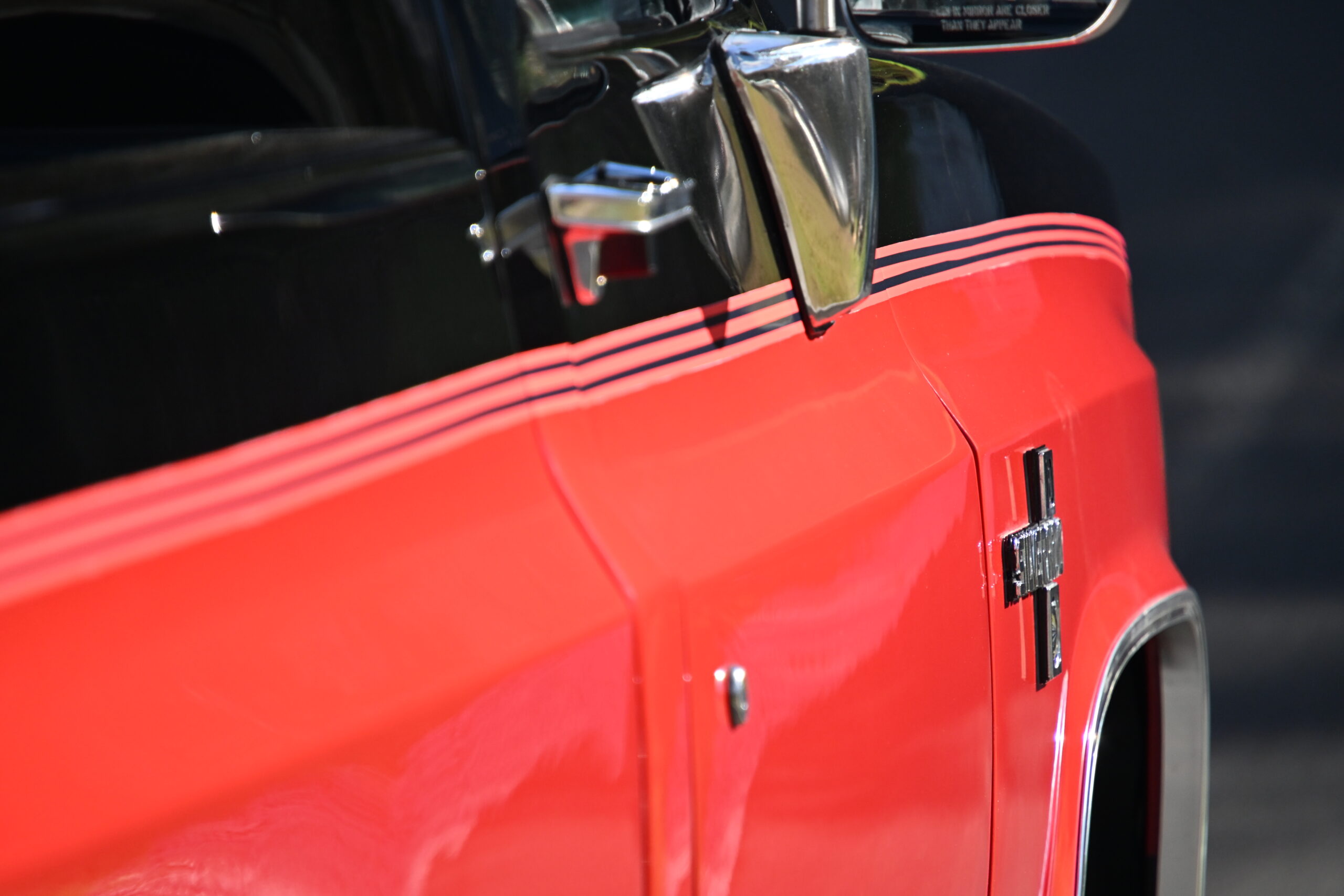 1986 Chevrolet SILVERADO — Detail of classic car exterior with red body and chrome handle.