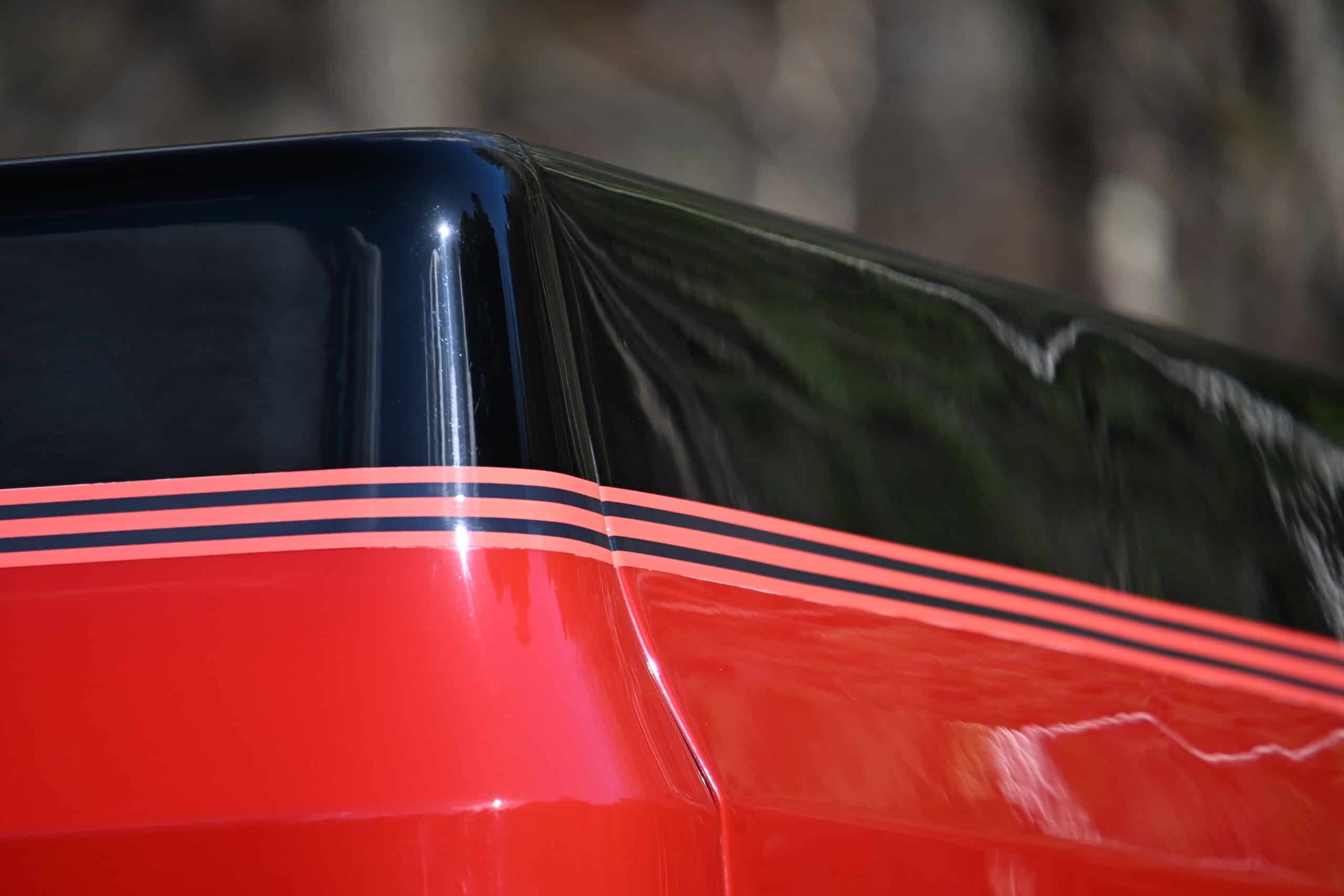 1986 Chevrolet SILVERADO — Close-up of the rear corner of a classic car with black and red paint.
