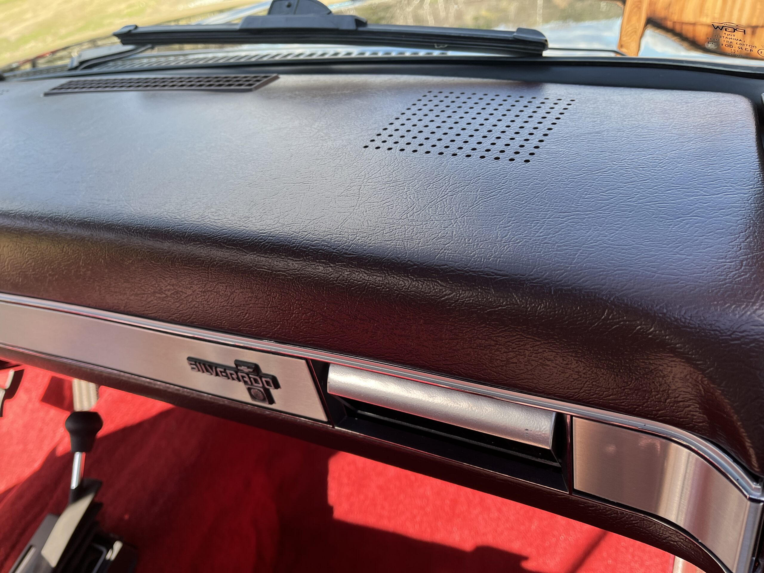 1986 Chevrolet SILVERADO — Close-up of classic car dashboard with speaker and glove box.