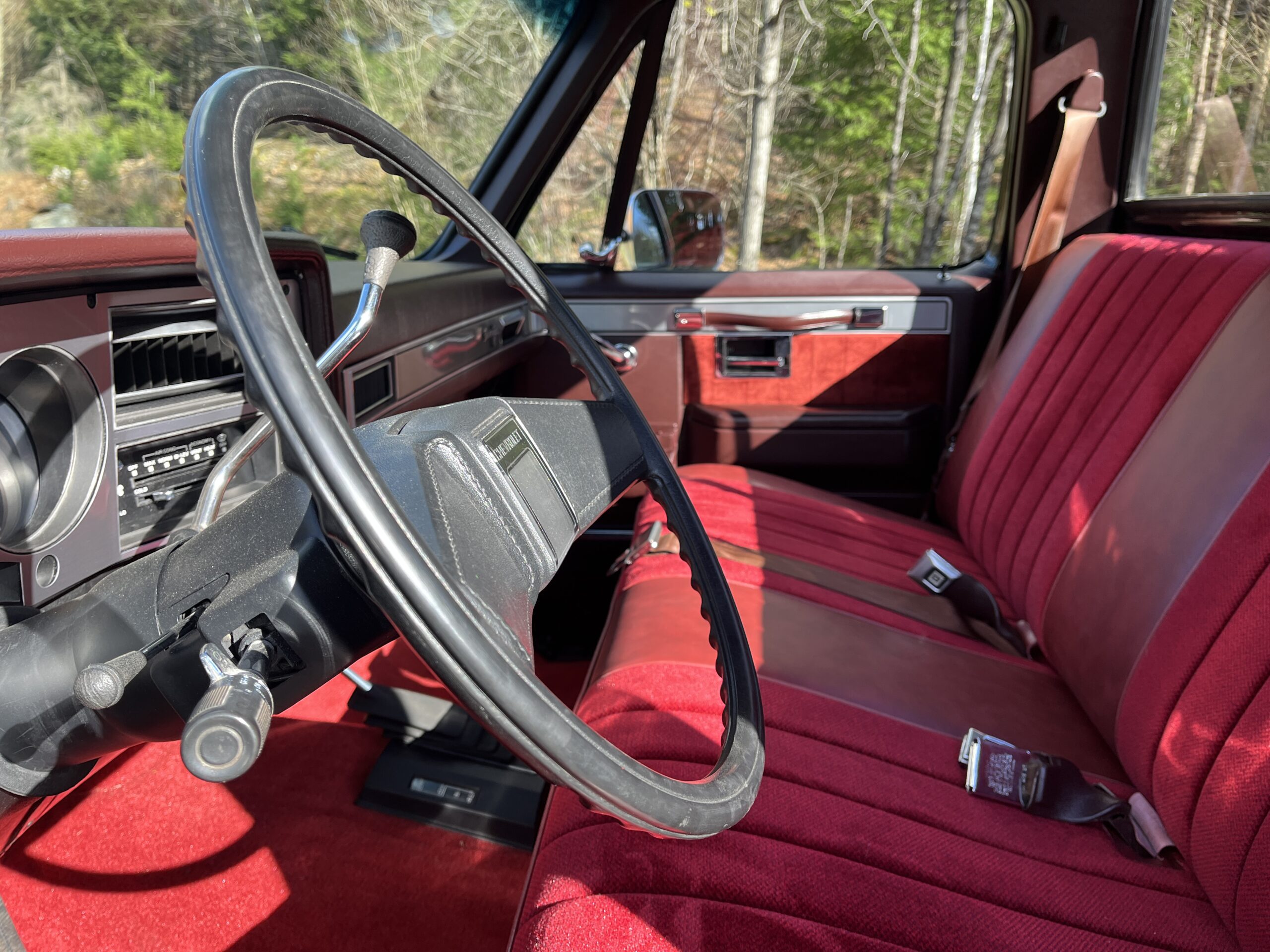1986 Chevrolet SILVERADO — Interior shot of a classic car with red seats and dashboard.