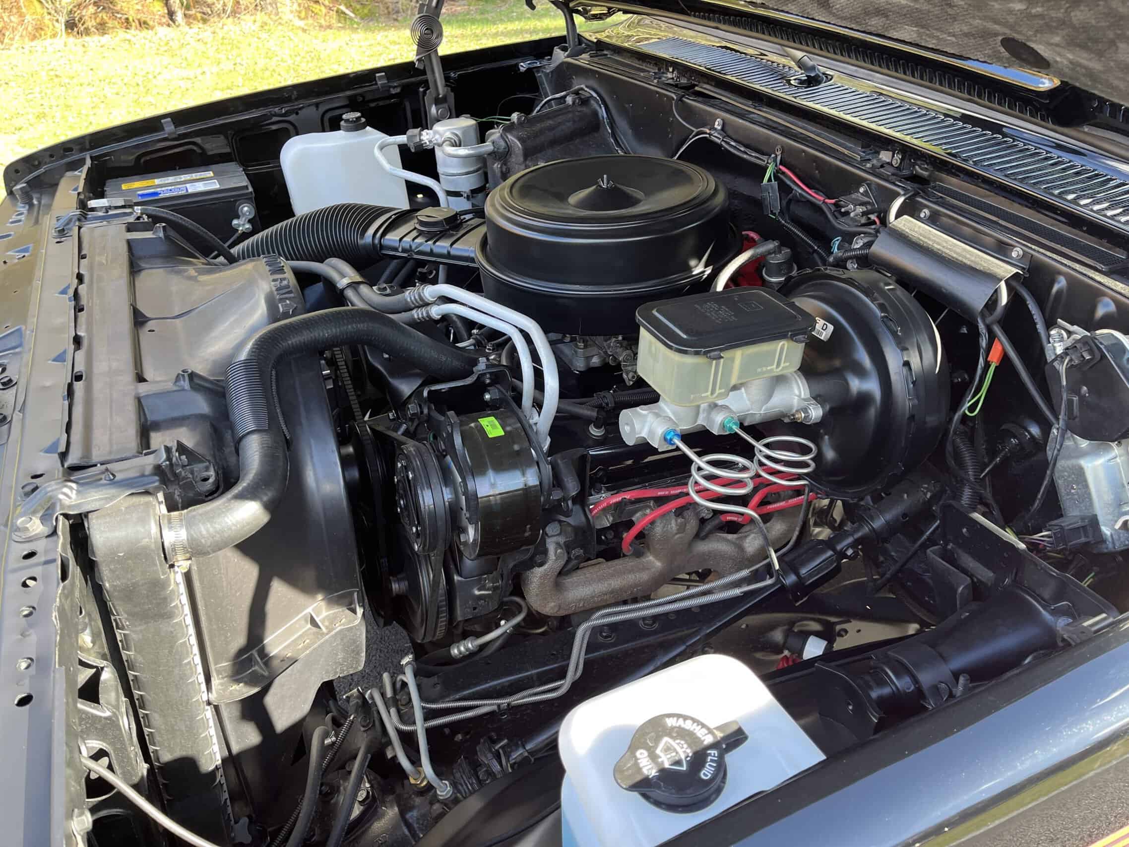 1986 Chevrolet SILVERADO — Close-up of classic car engine with air filter and hoses.