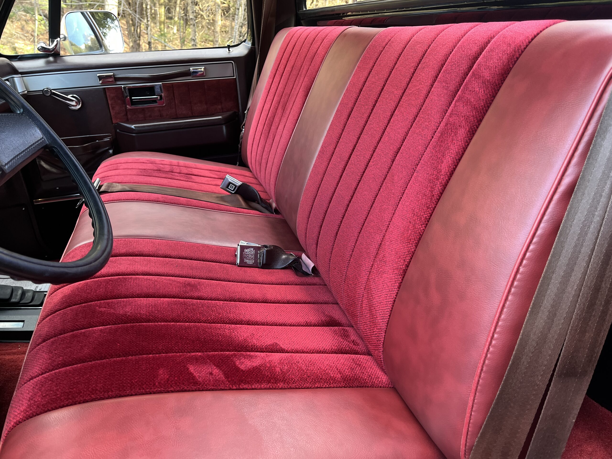 1986 Chevrolet SILVERADO — Red fabric and leather bench seat in classic car interior.