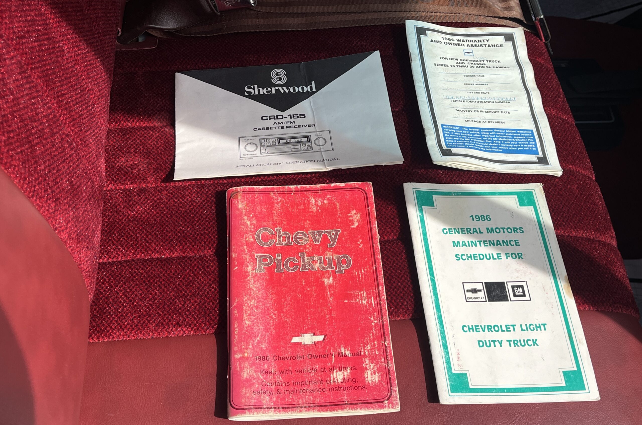 1986 Chevrolet SILVERADO — Interior shot of a classic car showing maintenance papers and manual.