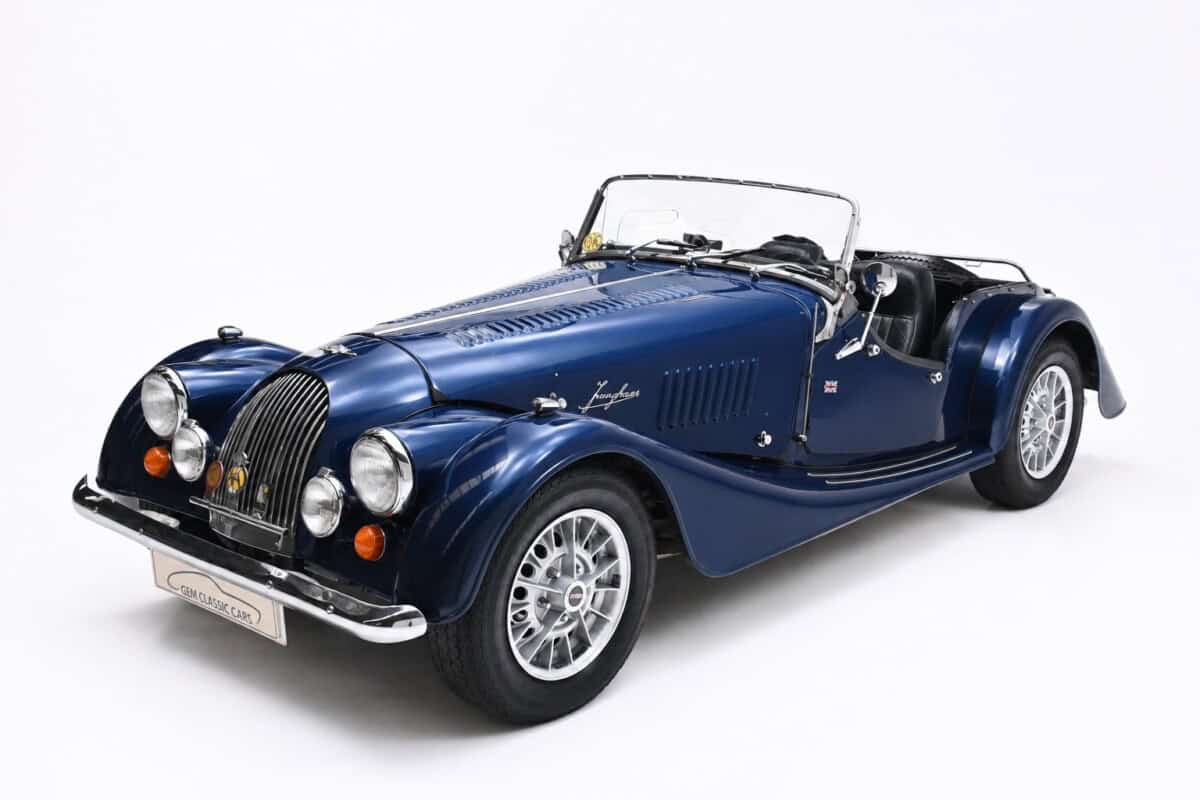1975 Morgan plus 8 — Classic car with open convertible top, blue body, and chrome details.