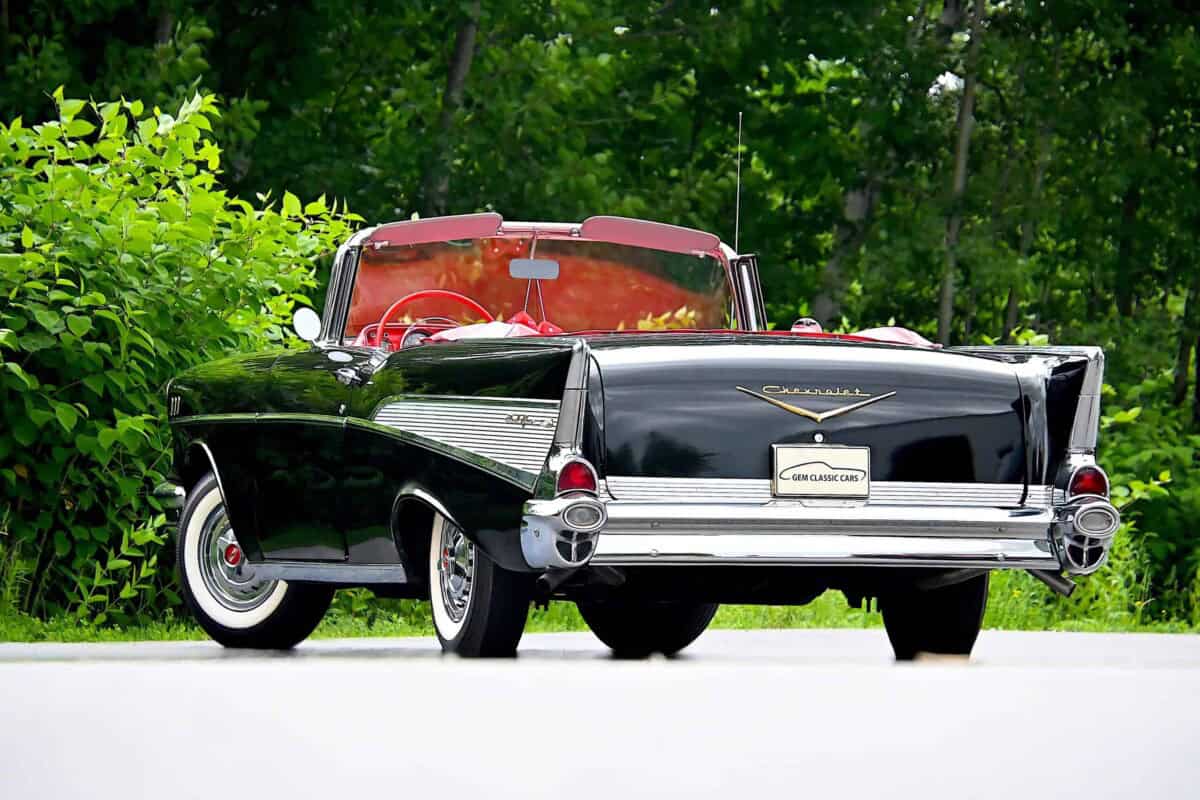 Exterior shot of a classic car with black body and red interior.