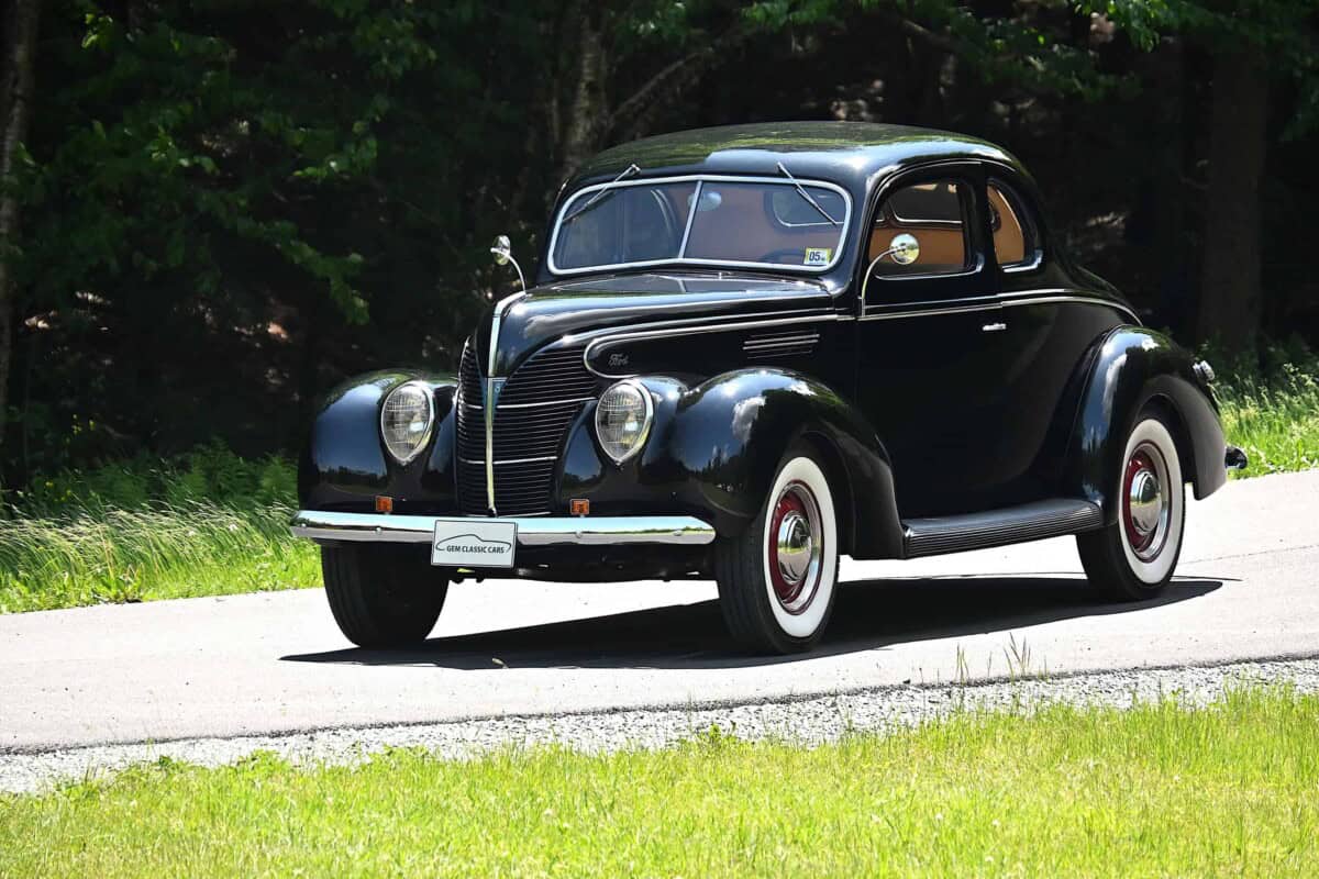 Exterior shot of a classic black car with rounded body style.