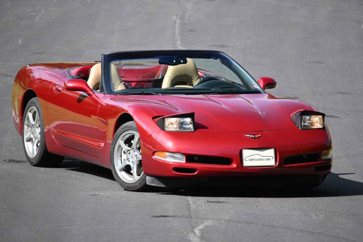 Red classic car convertible with beige interior on asphalt.