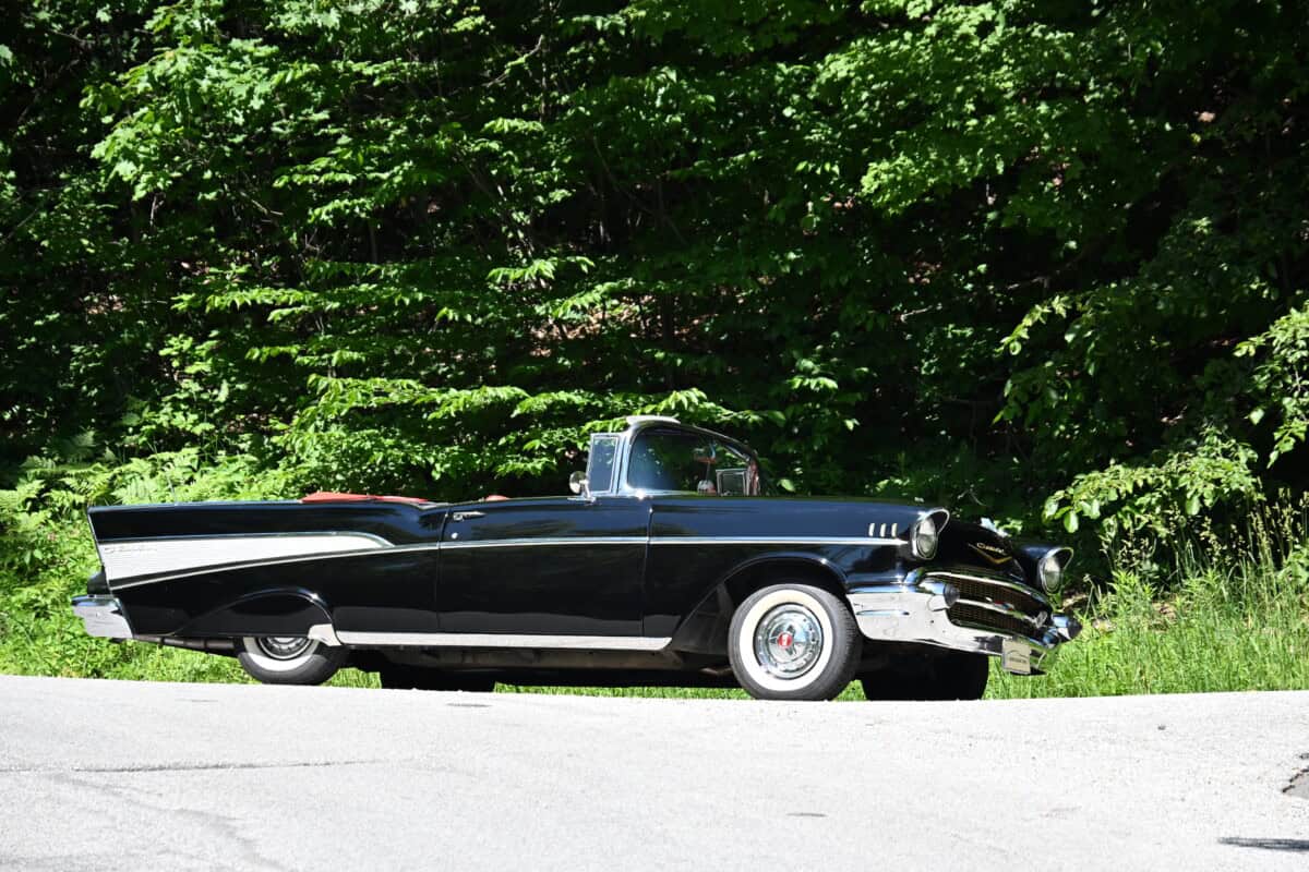 Side view of a black classic car parked on the road.
