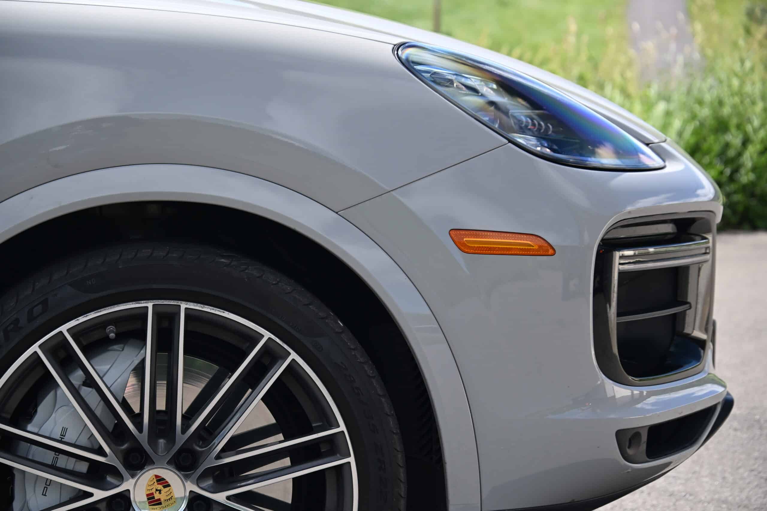 2022 Porsche Cayenne — Close-up of a classic car's front with headlight and wheel.