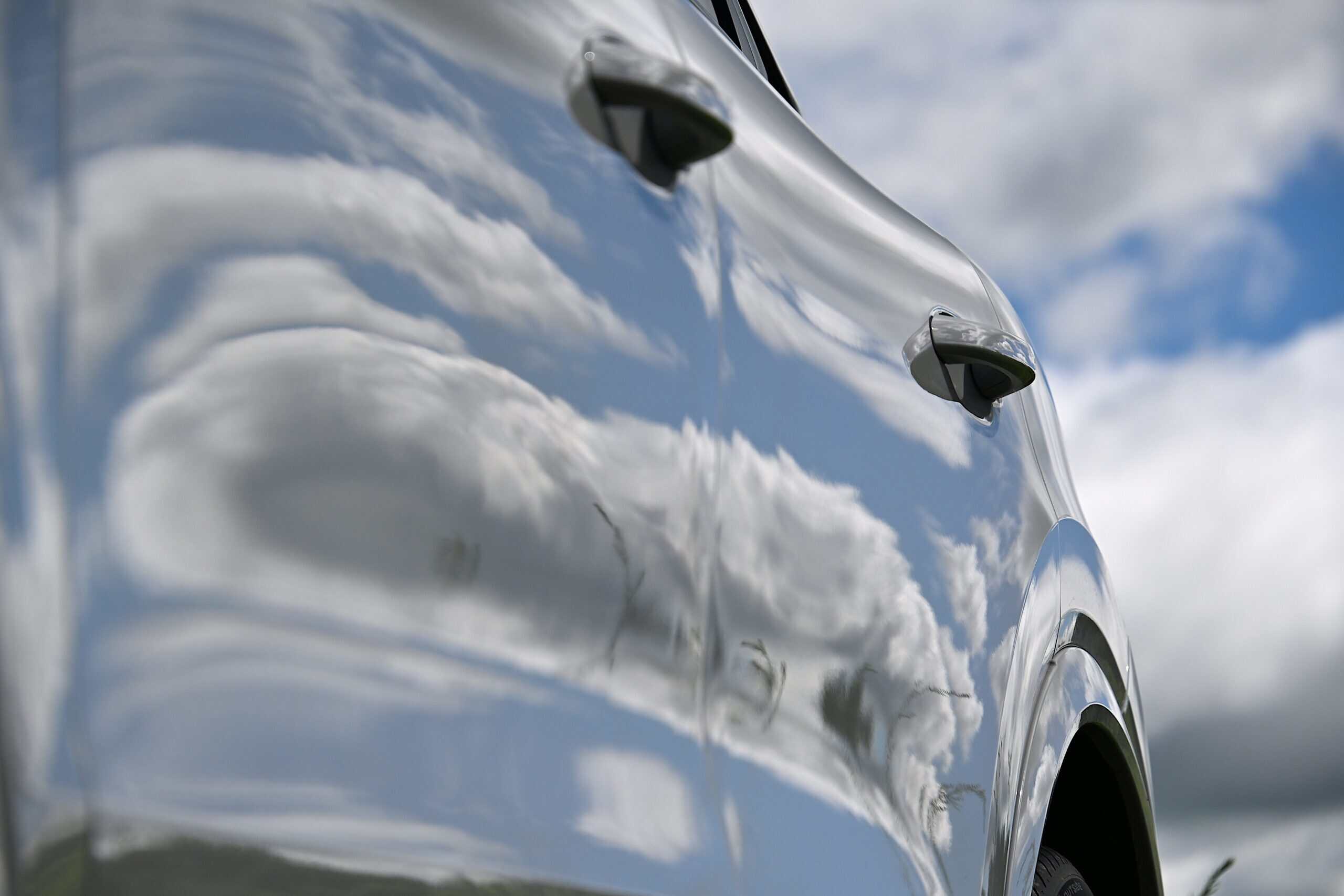 2022 Porsche Cayenne — Reflection of clouds on a shiny classic car body.