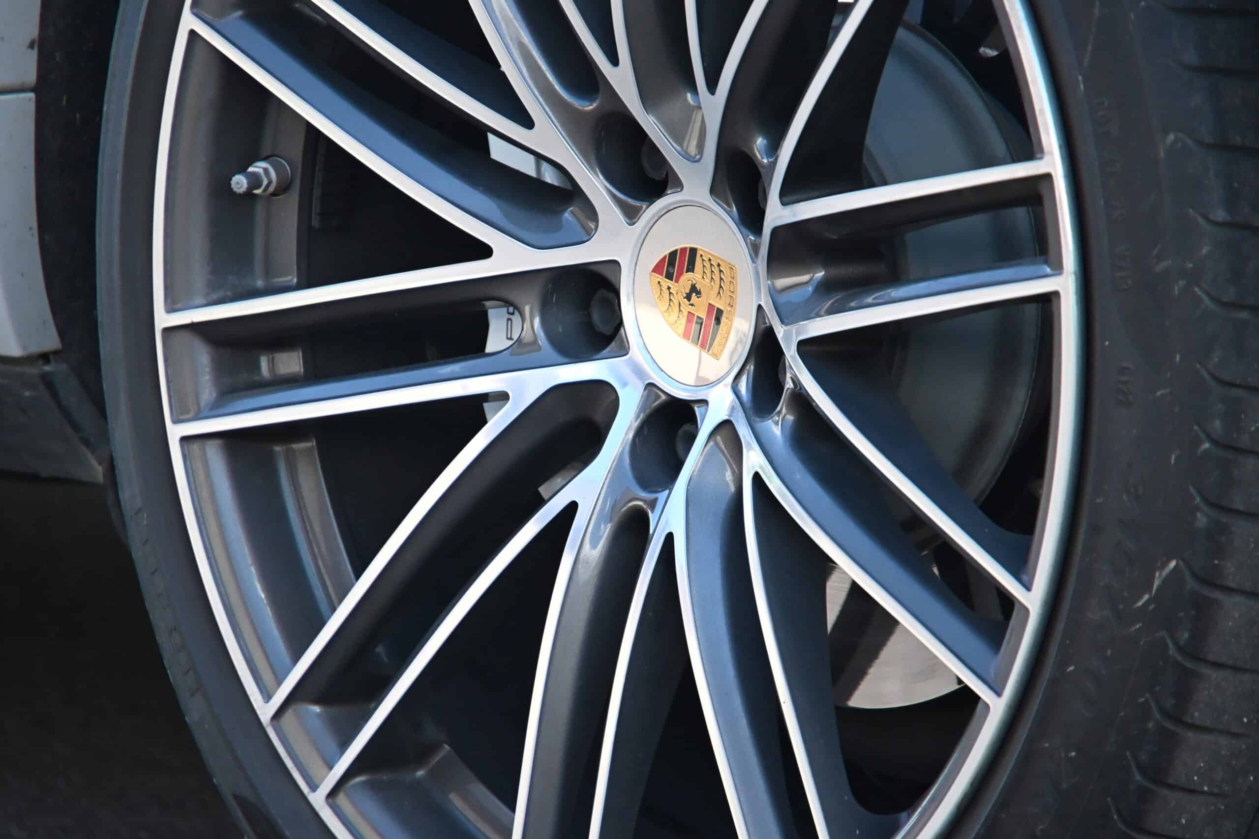 2022 Porsche Cayenne — Close-up of alloy wheel with Porsche logo on a classic car.