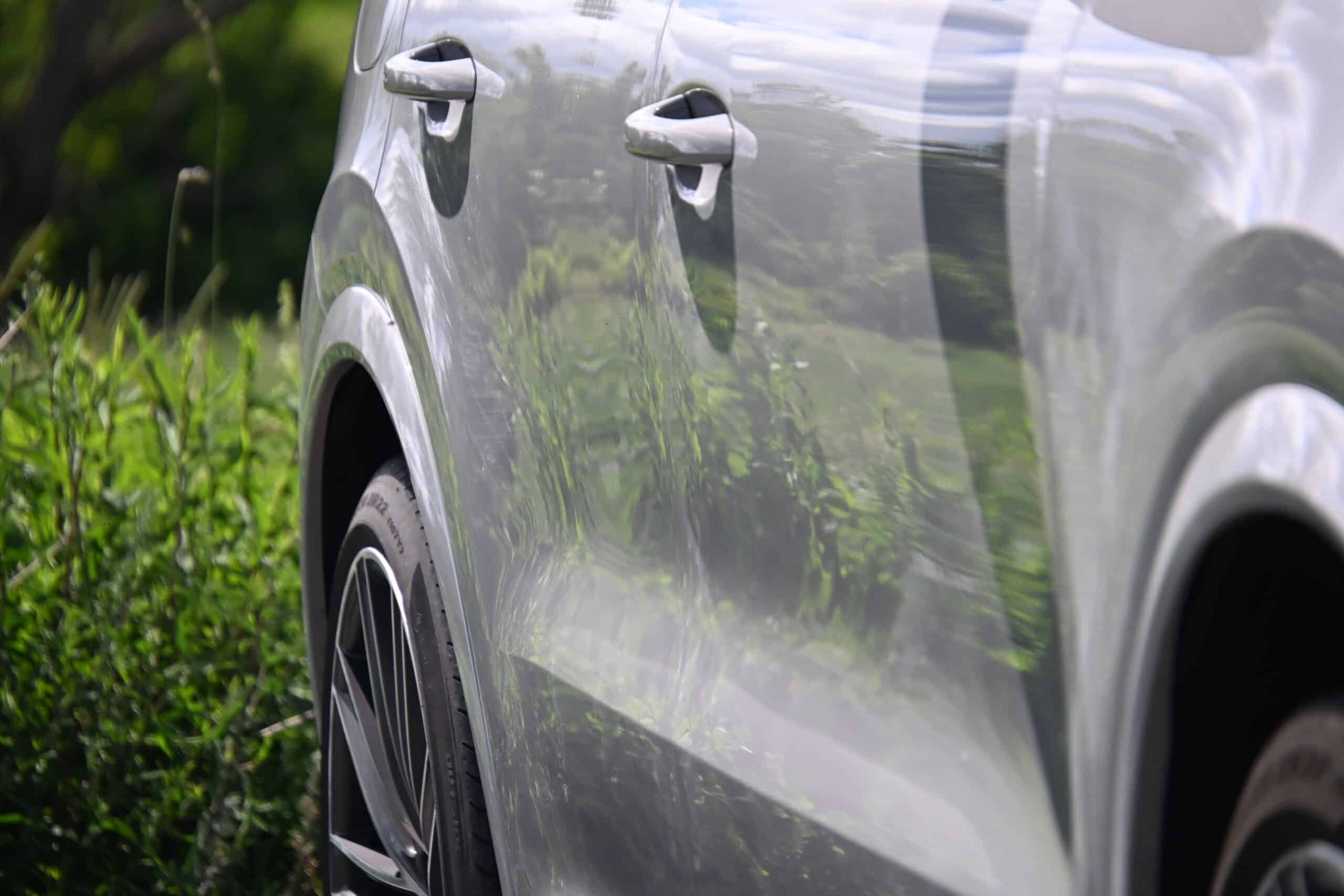 2022 Porsche Cayenne — Close-up of a classic car's side with shiny silver paint.