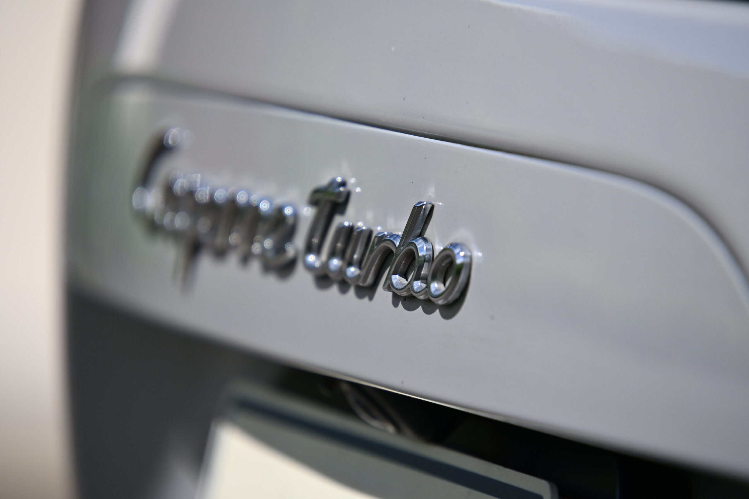 2022 Porsche Cayenne — Close-up of classic car emblem on silver exterior.