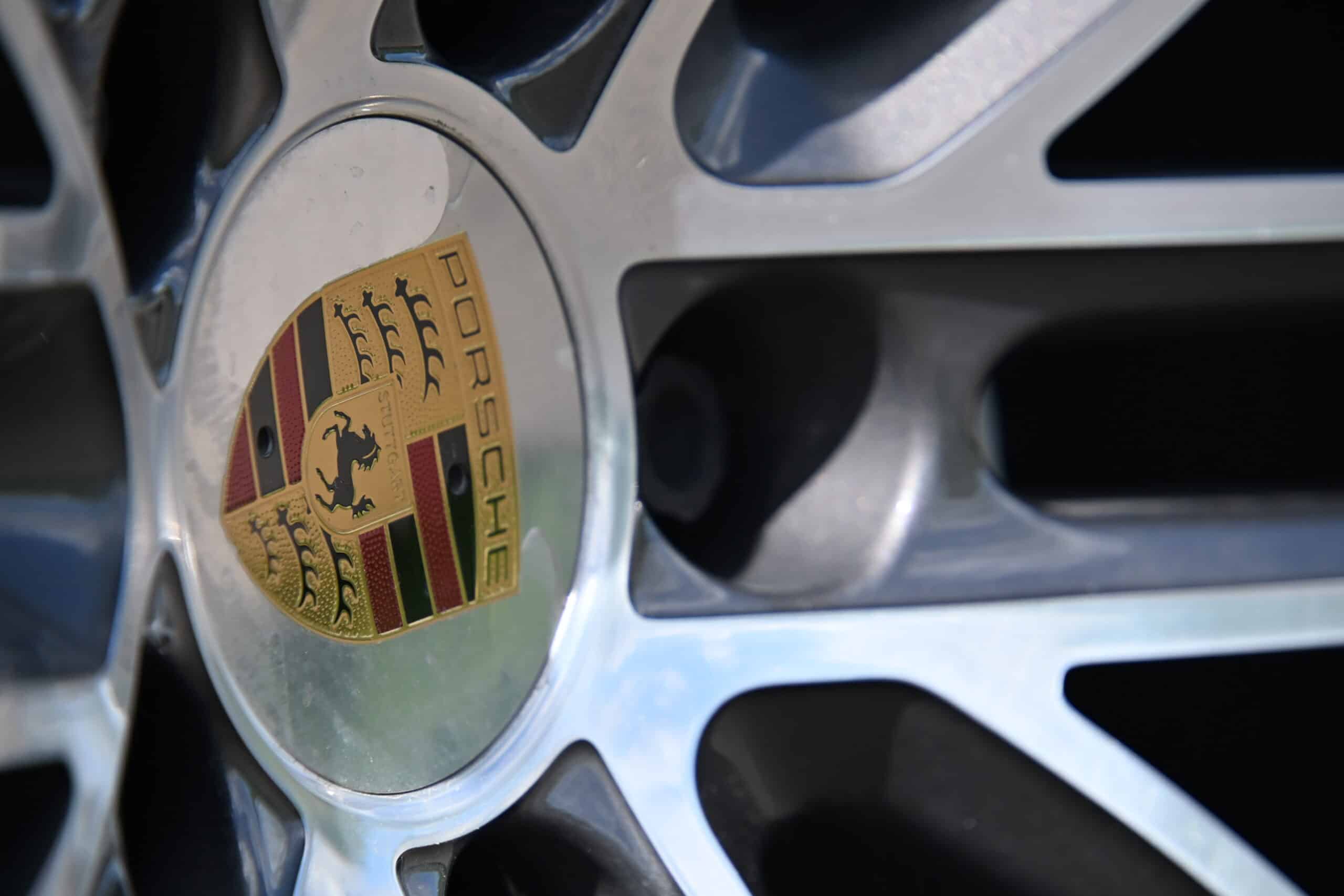 2022 Porsche Cayenne — Close-up of classic car wheel with Porsche logo and alloy rim.