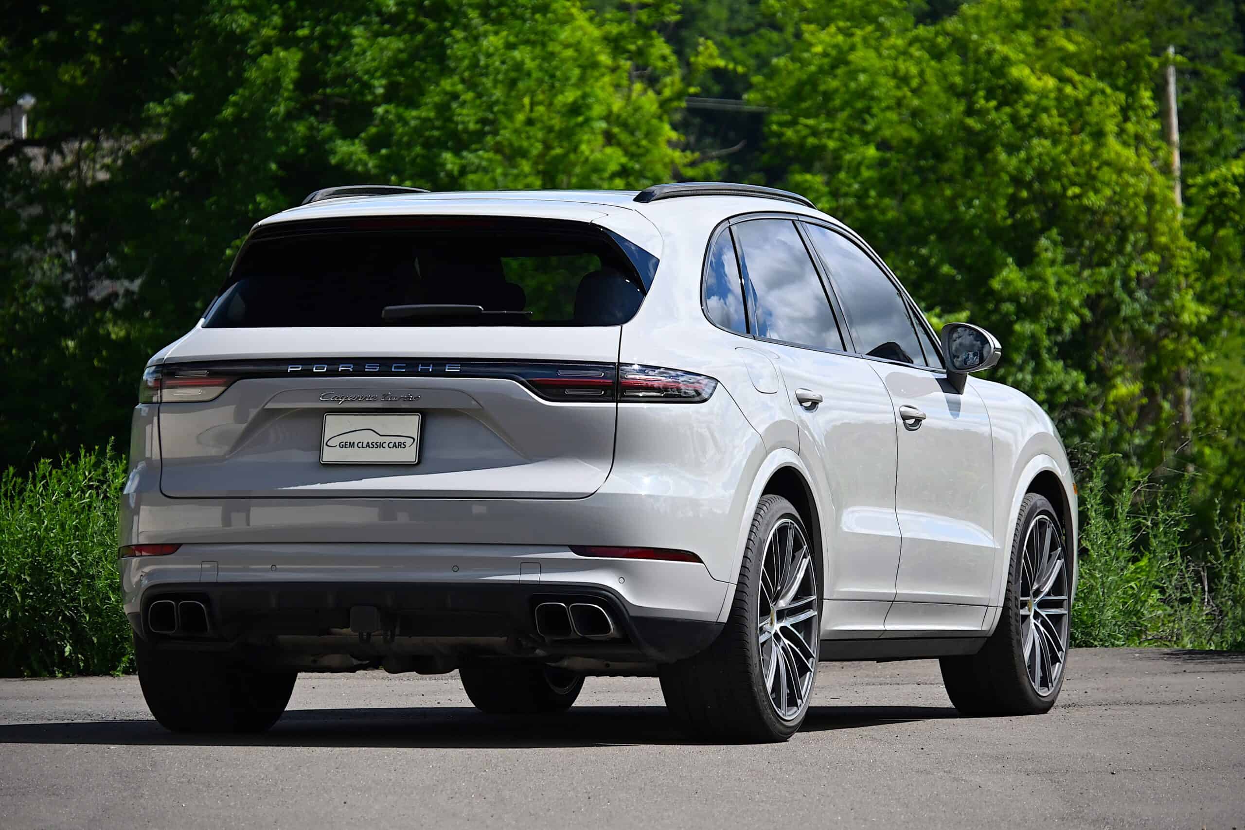 2022 Porsche Cayenne — White classic car SUV exterior shot with green background.