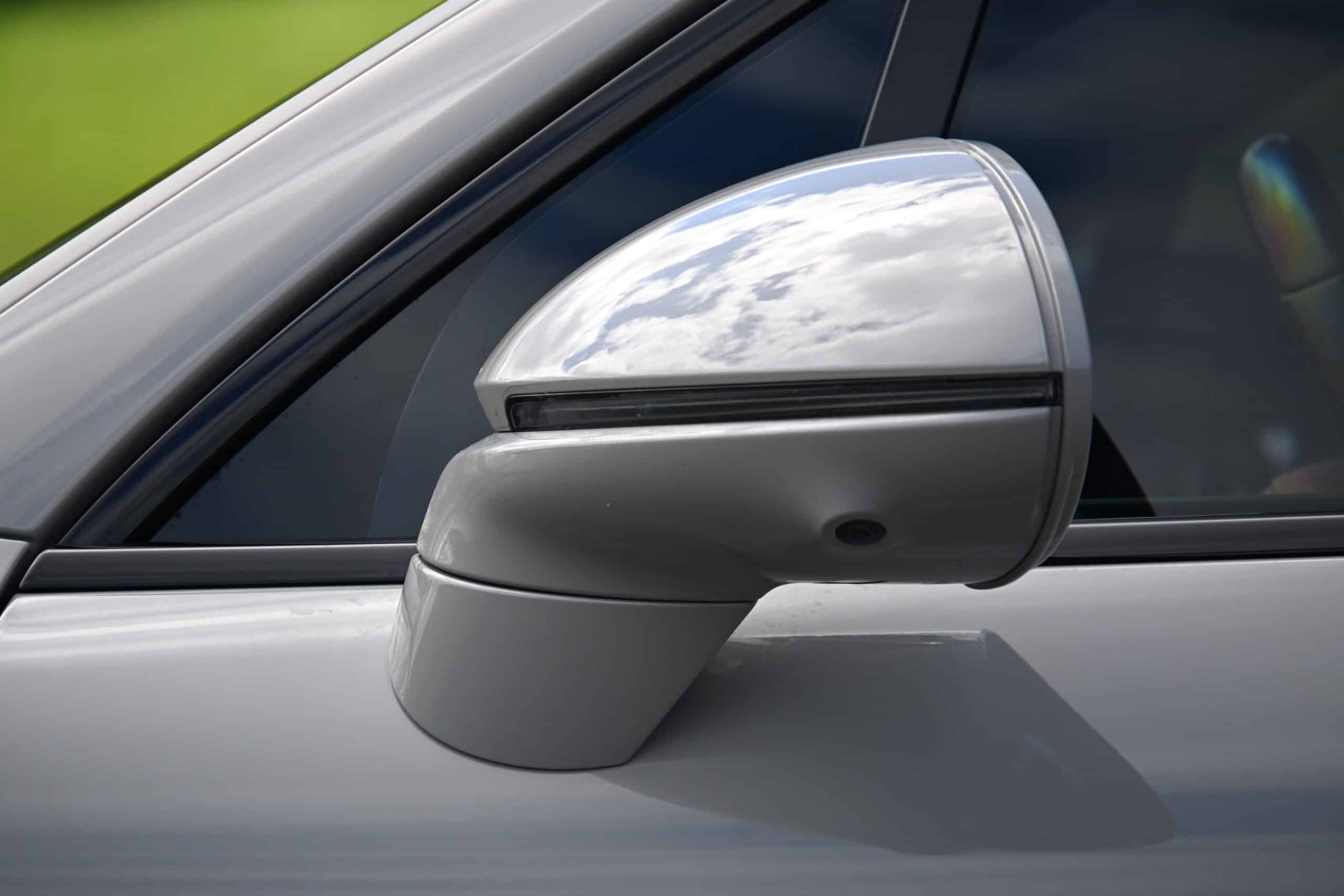 2022 Porsche Cayenne — Classic car side mirror with reflective surface and black trim.