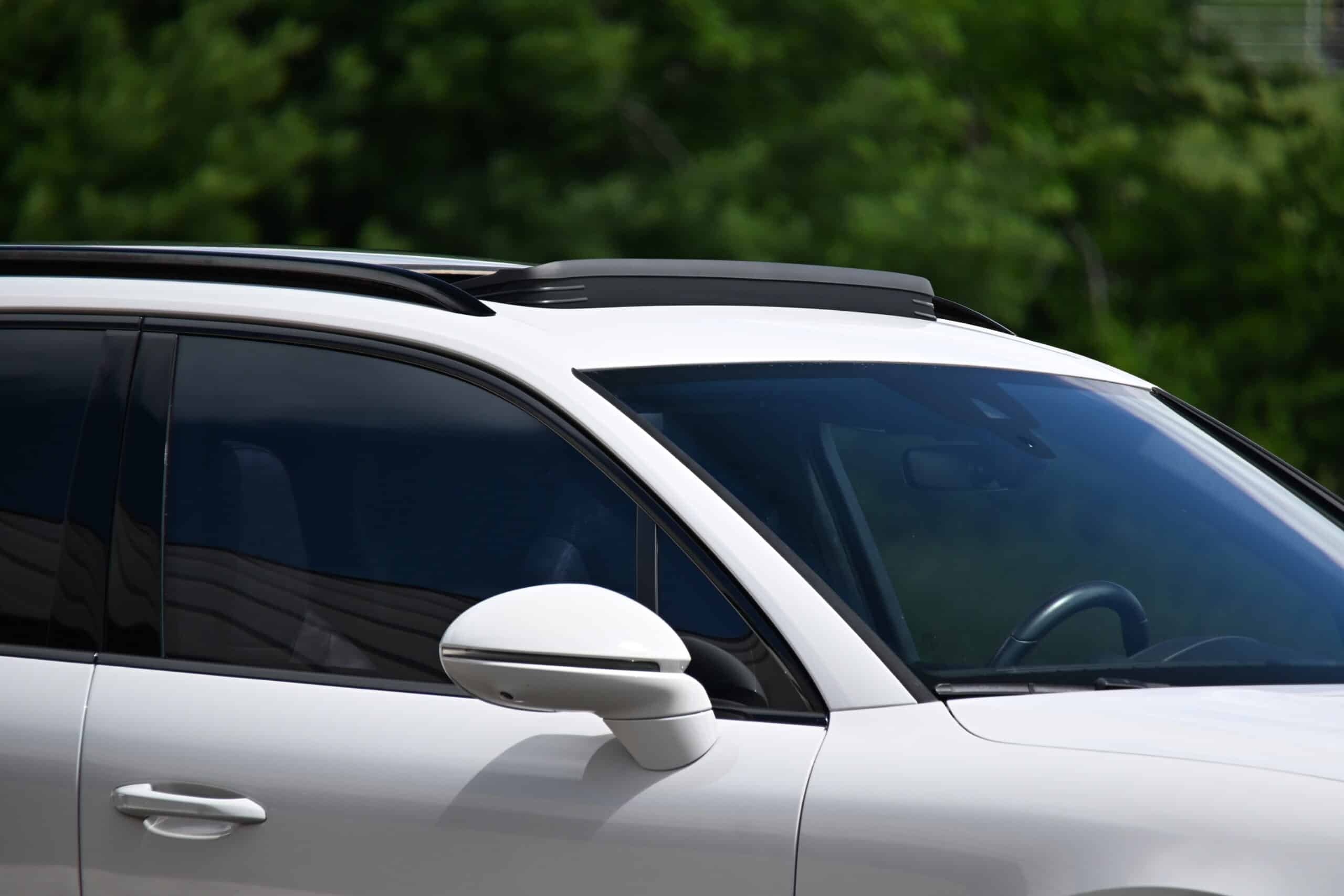2022 Porsche Cayenne — Close-up of a white classic car's exterior with sunroof and tinted windows.