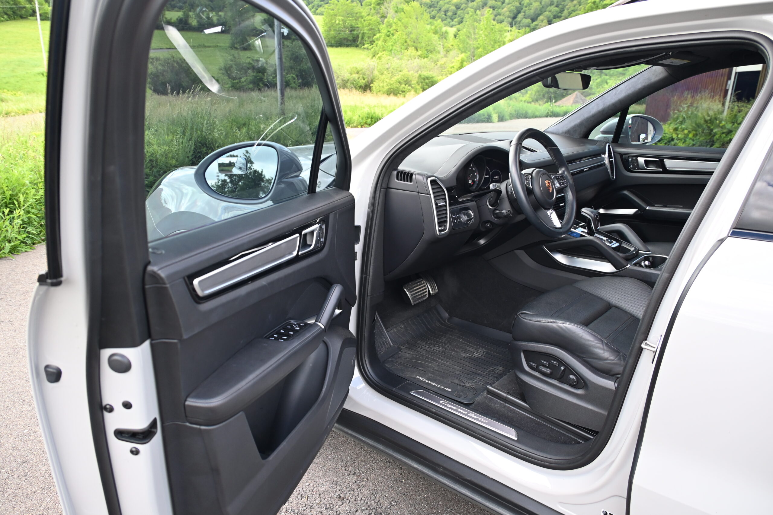 2022 Porsche Cayenne — Interior view of a classic car with open door showing dashboard and seats.