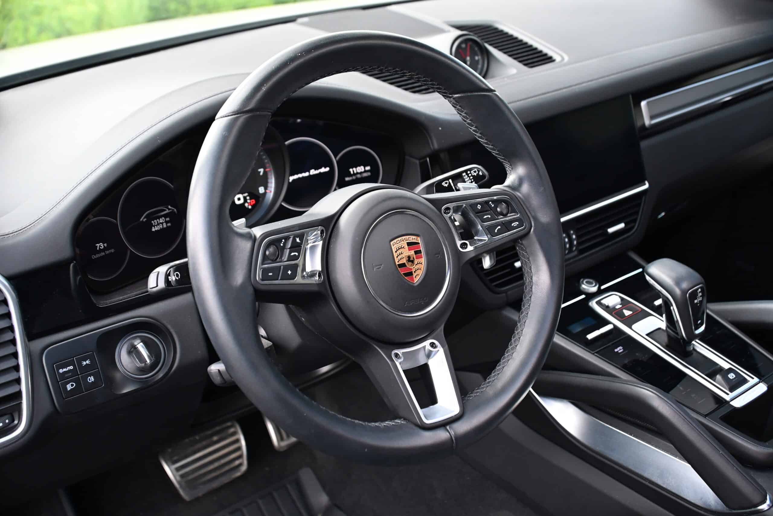 2022 Porsche Cayenne — Close-up of a classic car interior showing steering wheel and dashboard.
