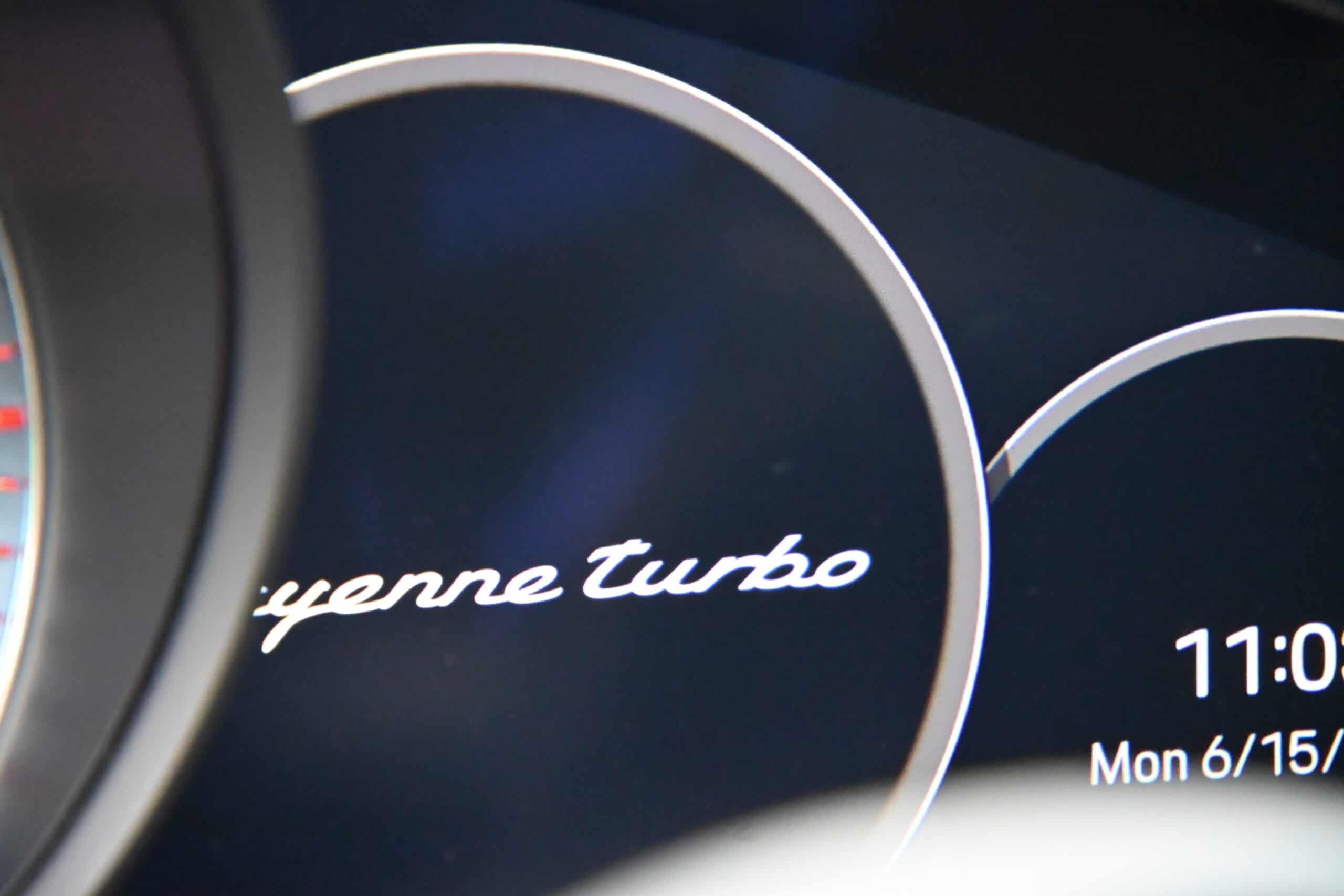 2022 Porsche Cayenne — Dashboard of a classic car showing Porsche Cayenne Turbo logo.