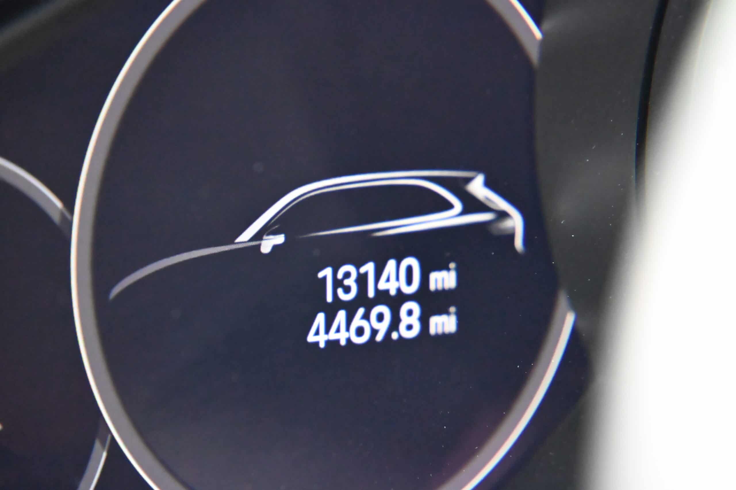 2022 Porsche Cayenne — Close-up of classic car dashboard showing mileage and trip distance.