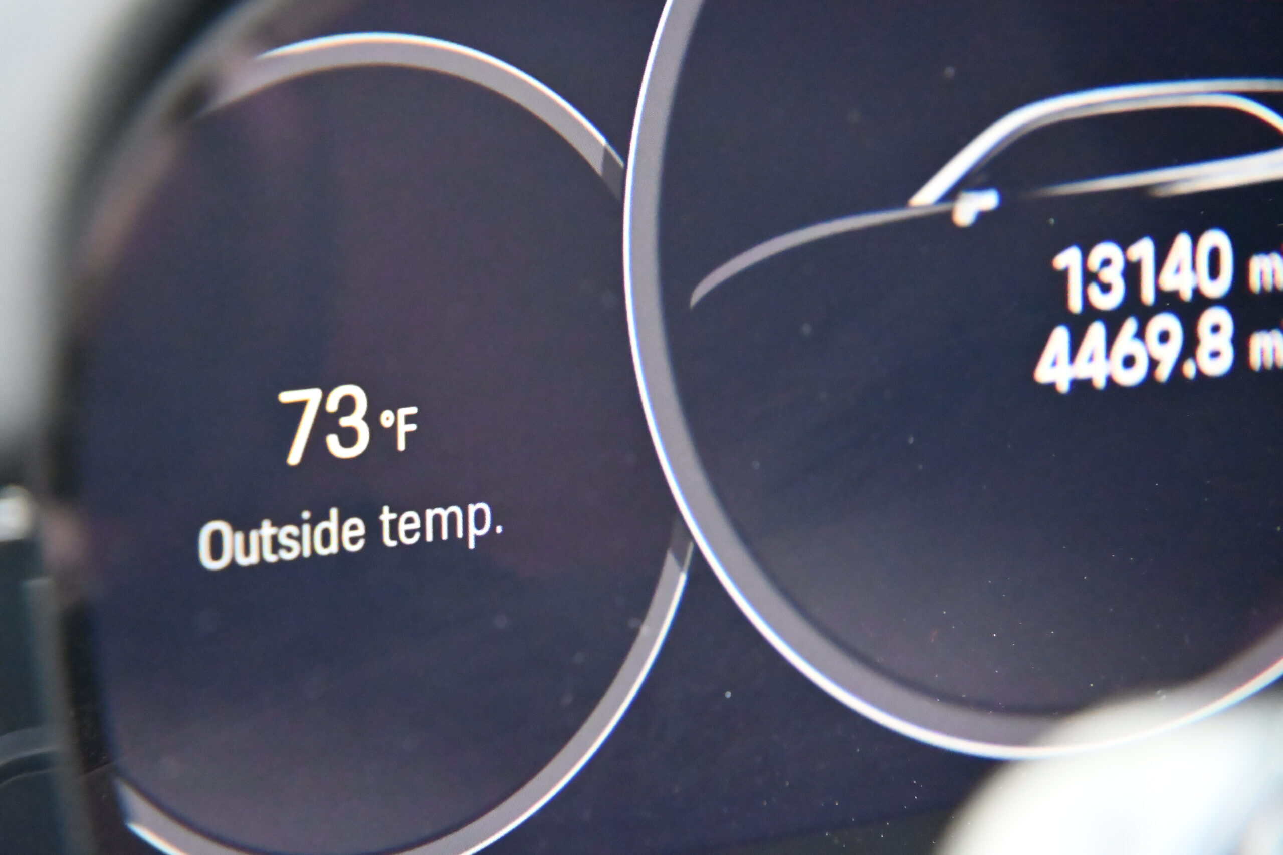 2022 Porsche Cayenne — Close-up of classic car dashboard showing outside temperature and odometer.