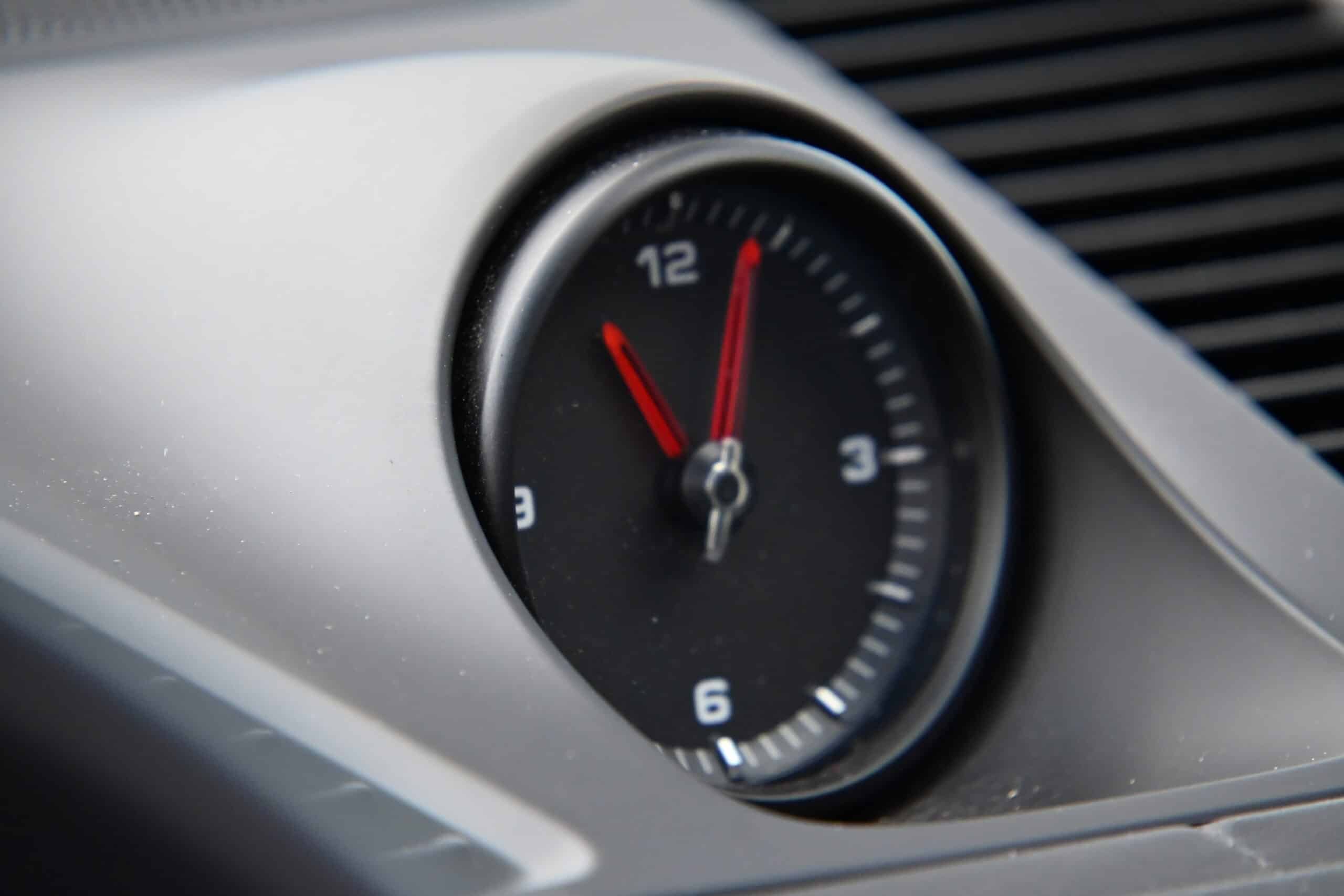 2022 Porsche Cayenne — Close-up of round dashboard clock in classic car interior.