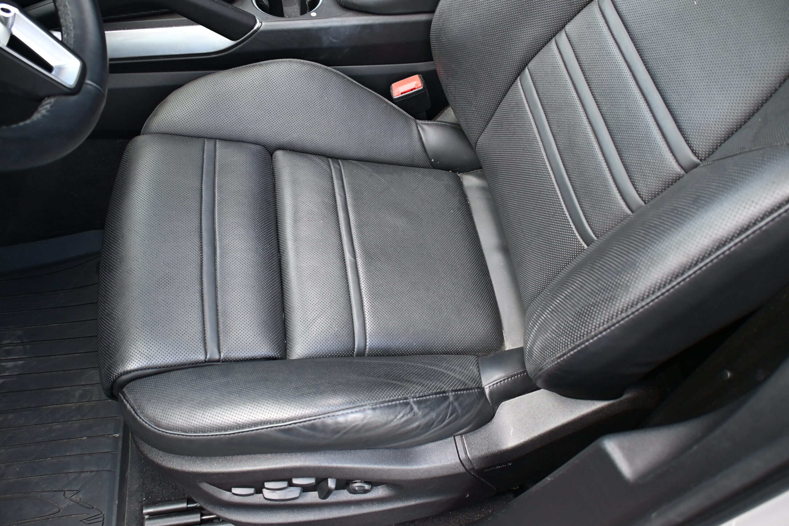 2022 Porsche Cayenne — Close-up of black leather interior seat in a classic car.