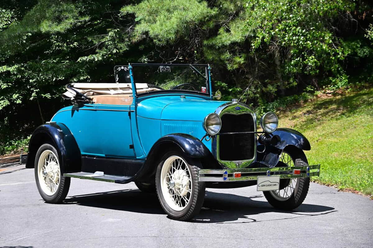 Blue classic car convertible with black fenders and white wheels.