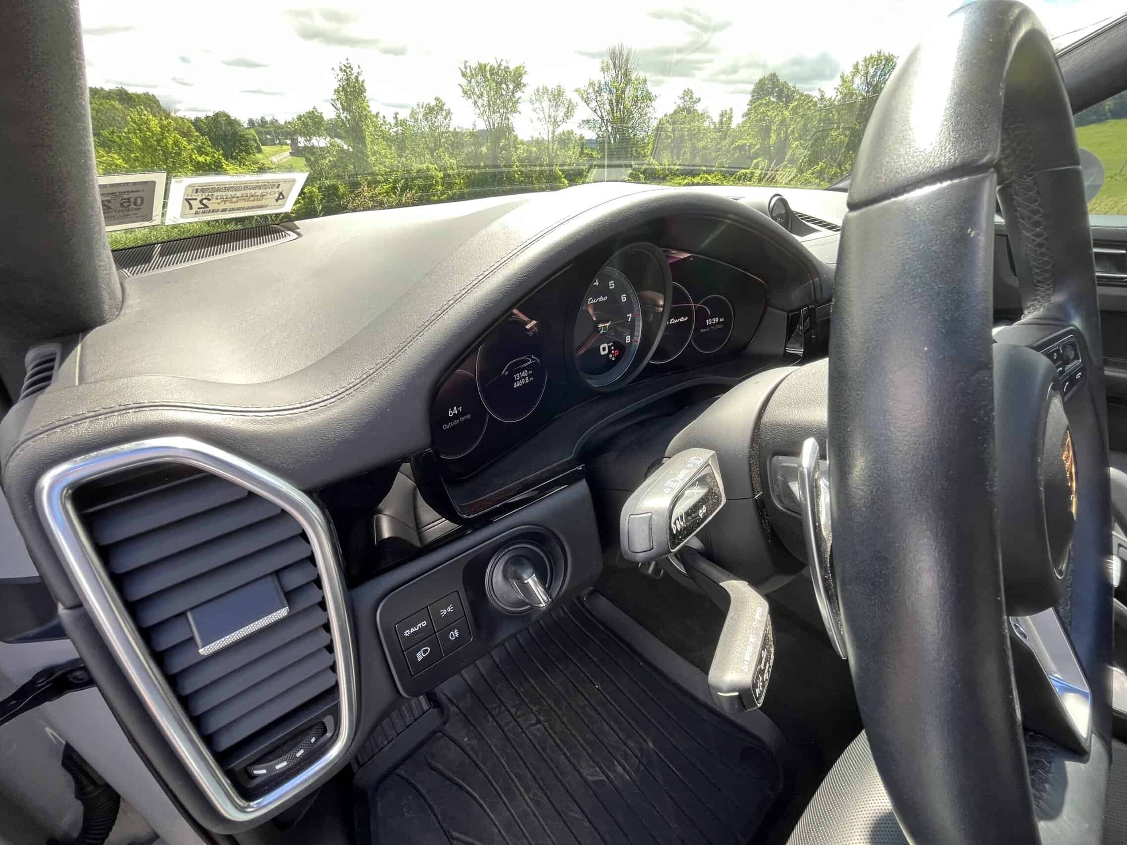2022 Porsche Cayenne — Close-up of classic car interior with dashboard and steering wheel.
