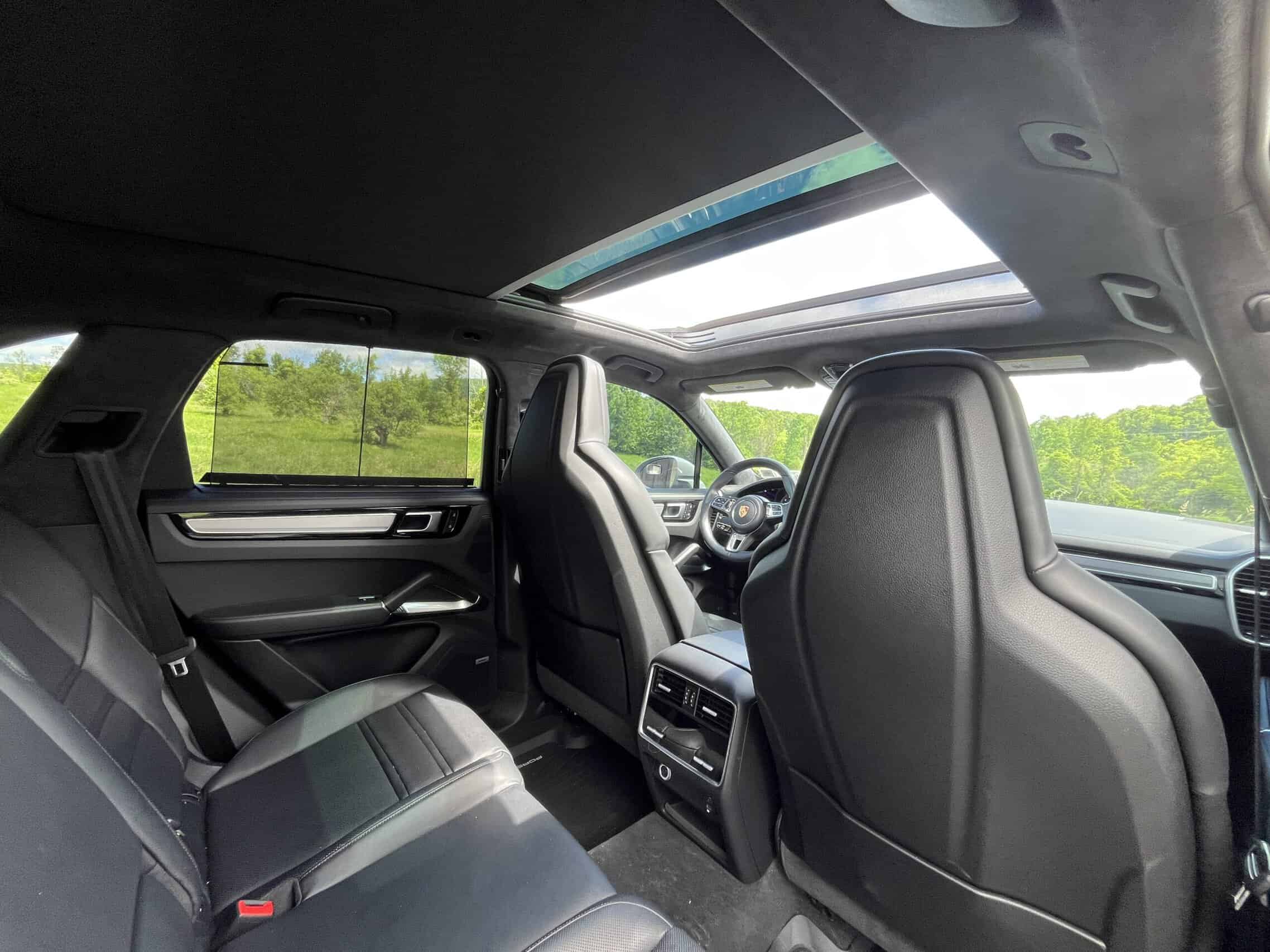 2022 Porsche Cayenne — Interior view of a classic car with panoramic sunroof and black seats.