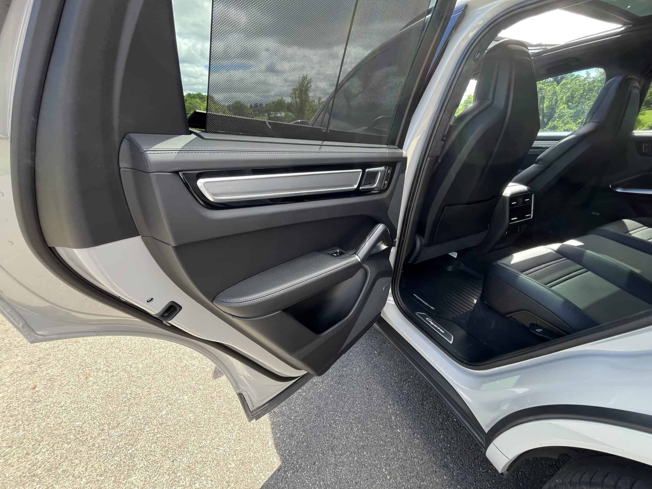 2022 Porsche Cayenne — Close-up of a modern car interior door panel with handle and window control.