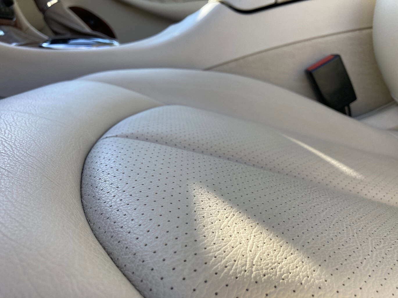 1999 Mercedes CLK500 — Close-up of a beige leather car seat with perforations and stitching.