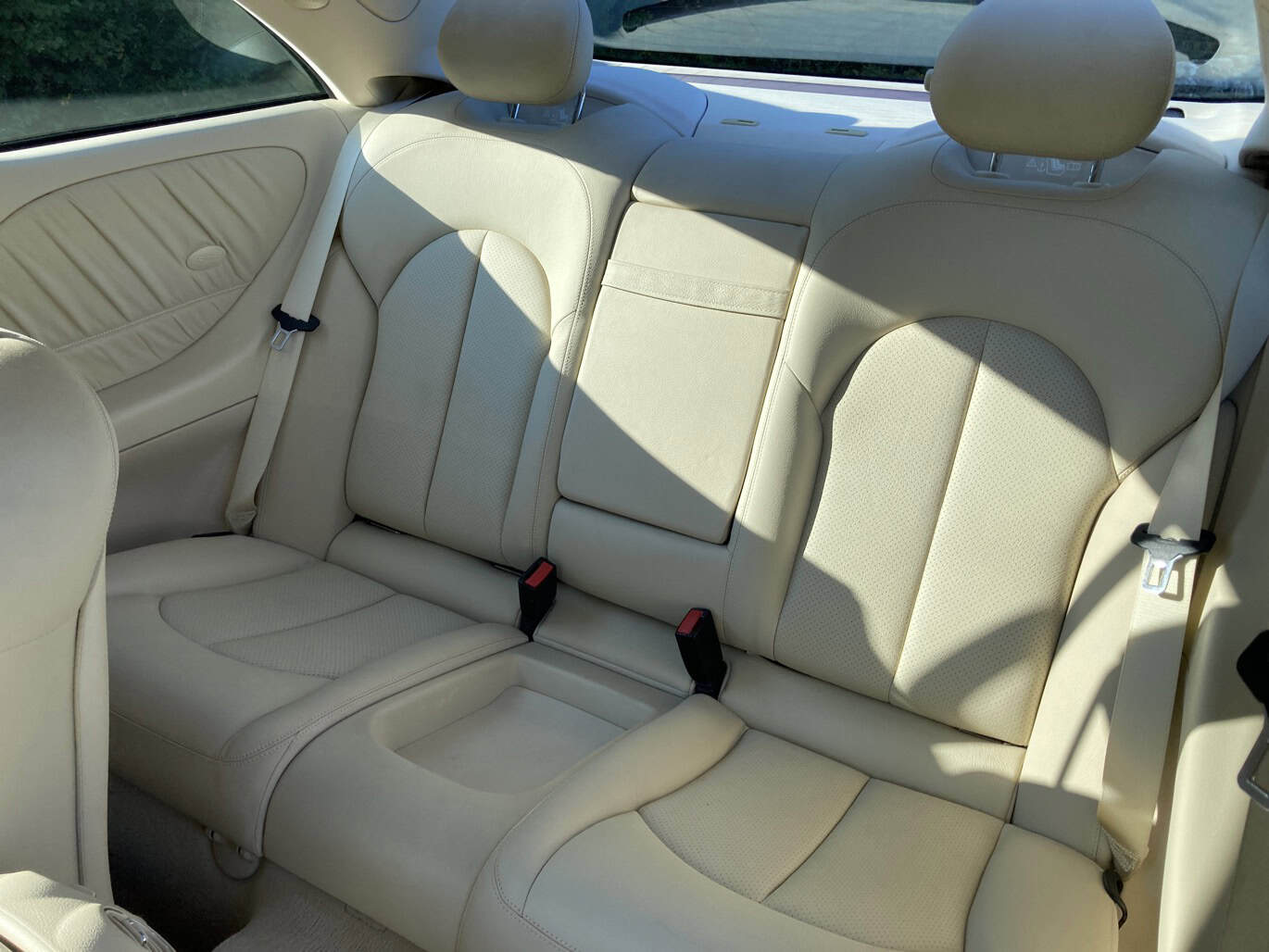 1999 Mercedes CLK500 — Interior shot of a classic car with beige leather seats and headrests.