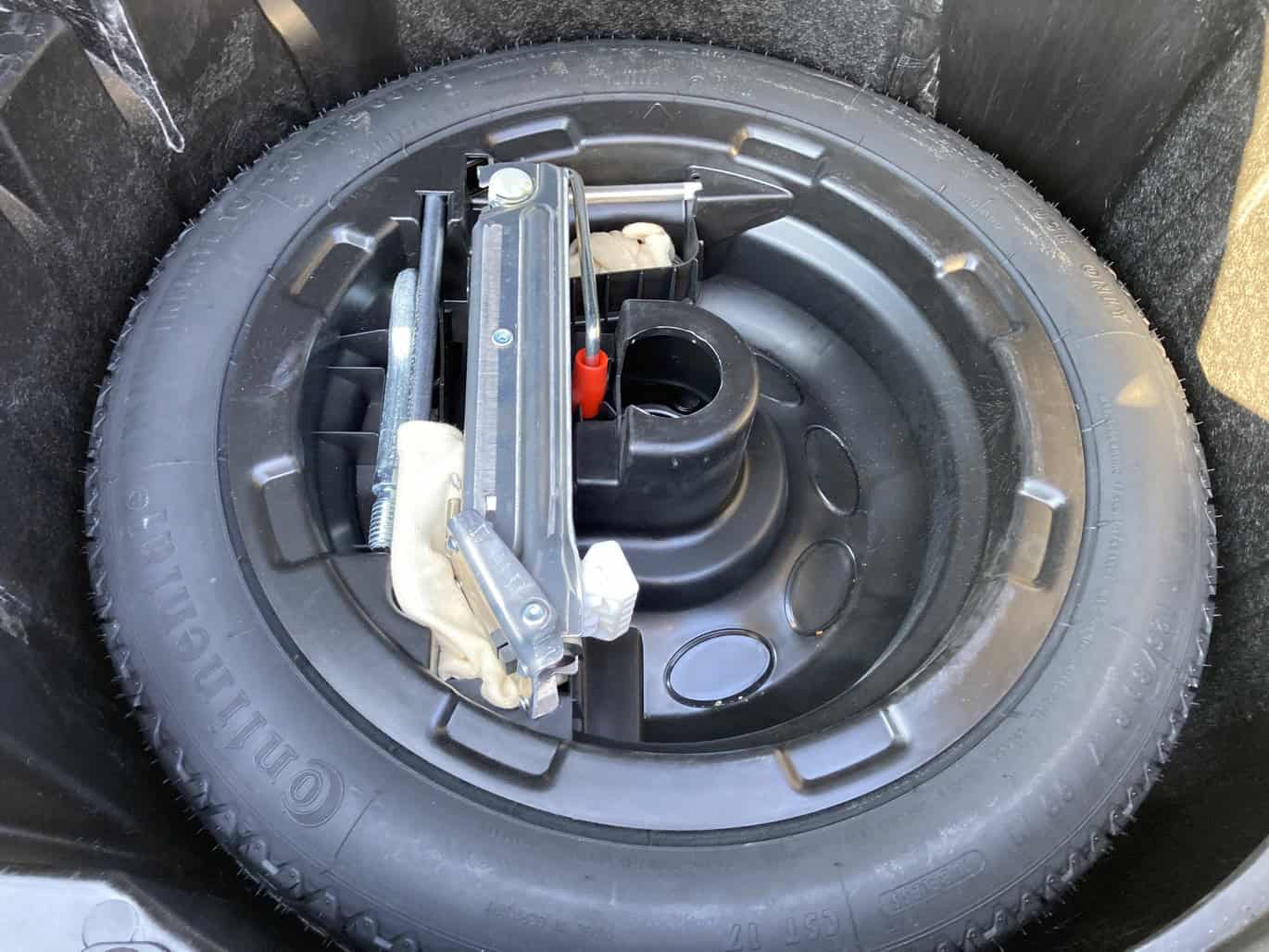 1999 Mercedes CLK500 — Spare tire with jack and tools in trunk of classic car.