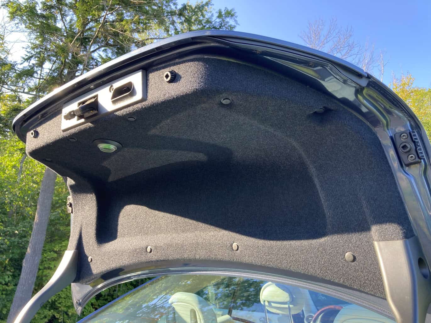 1999 Mercedes CLK500 — Open trunk of a classic car showing interior details.