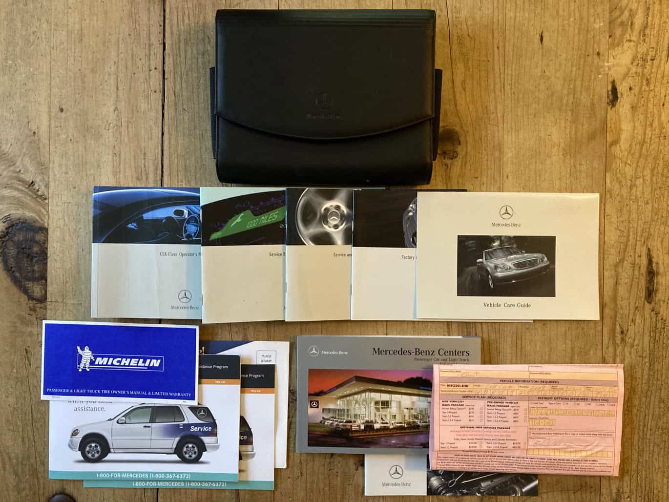 1999 Mercedes CLK500 — Collection of car manuals, service records, and accessories for classic car.