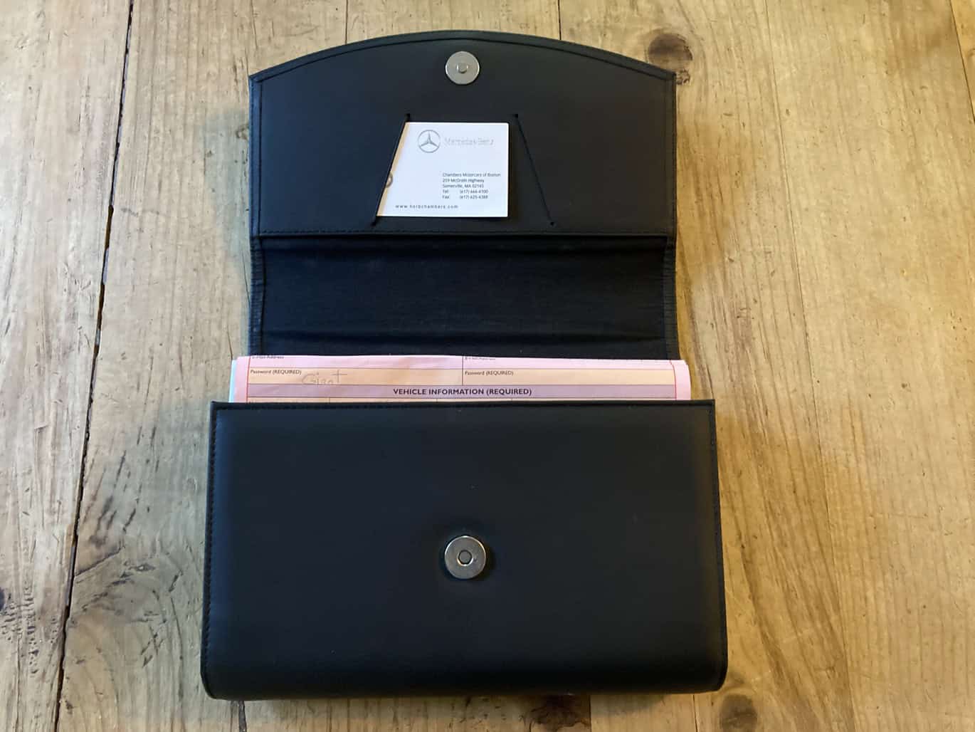 1999 Mercedes CLK500 — Black leather wallet with Mercedes-Benz key fob inside.