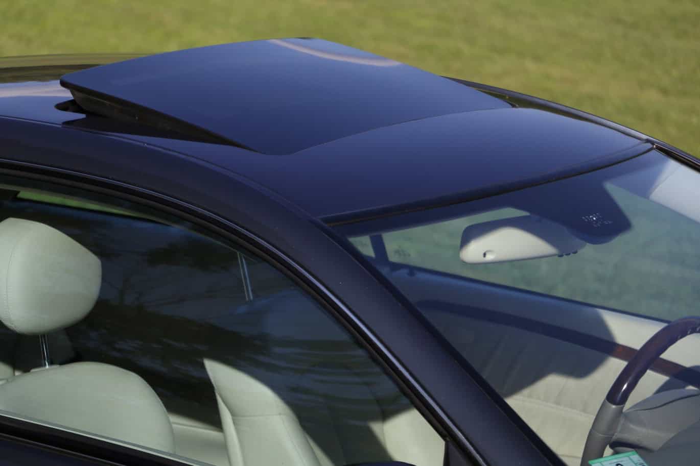 1999 Mercedes CLK500 — Exterior shot of a classic car with sunroof and beige interior.